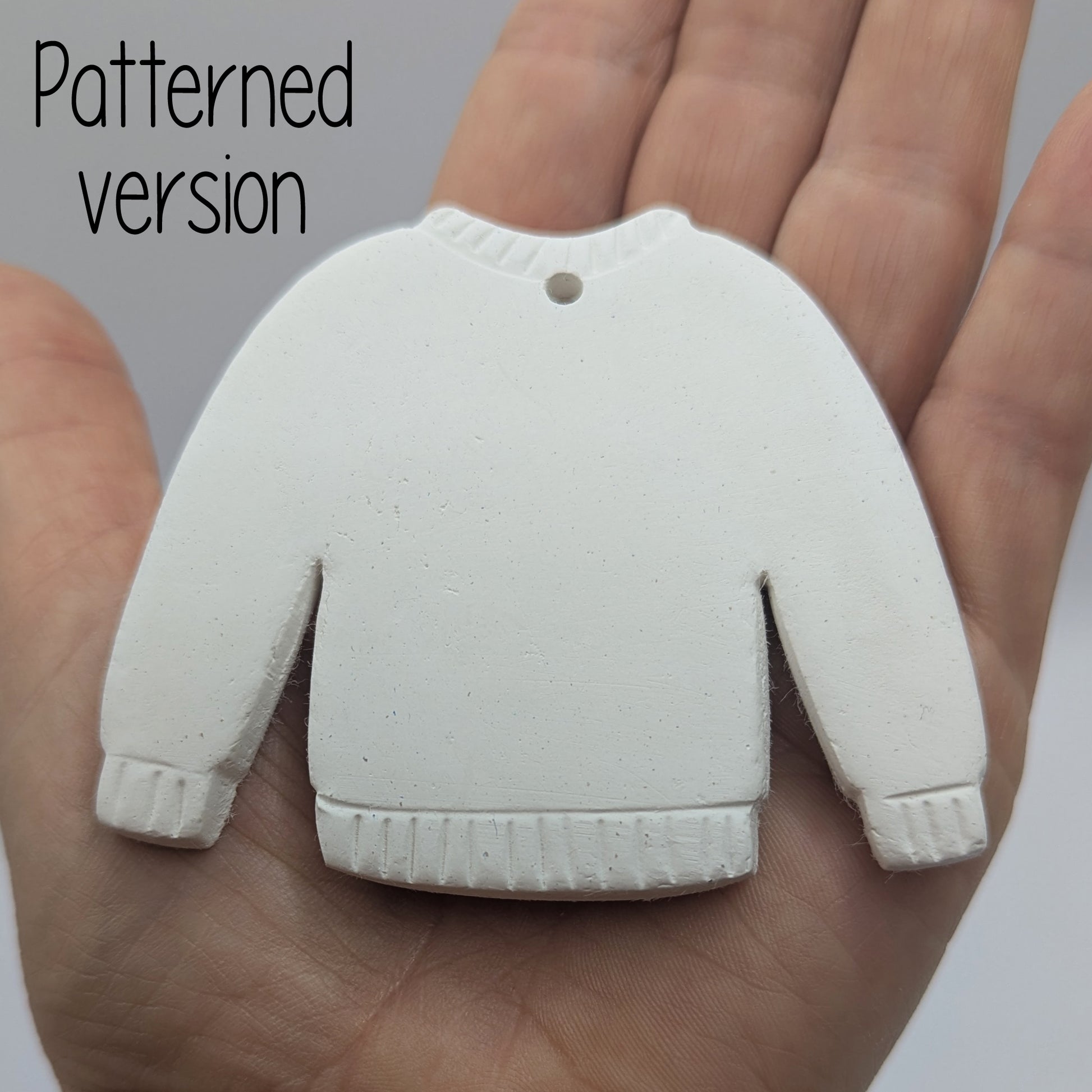 Jumper clay decoration being held in the palm of a hand to show size