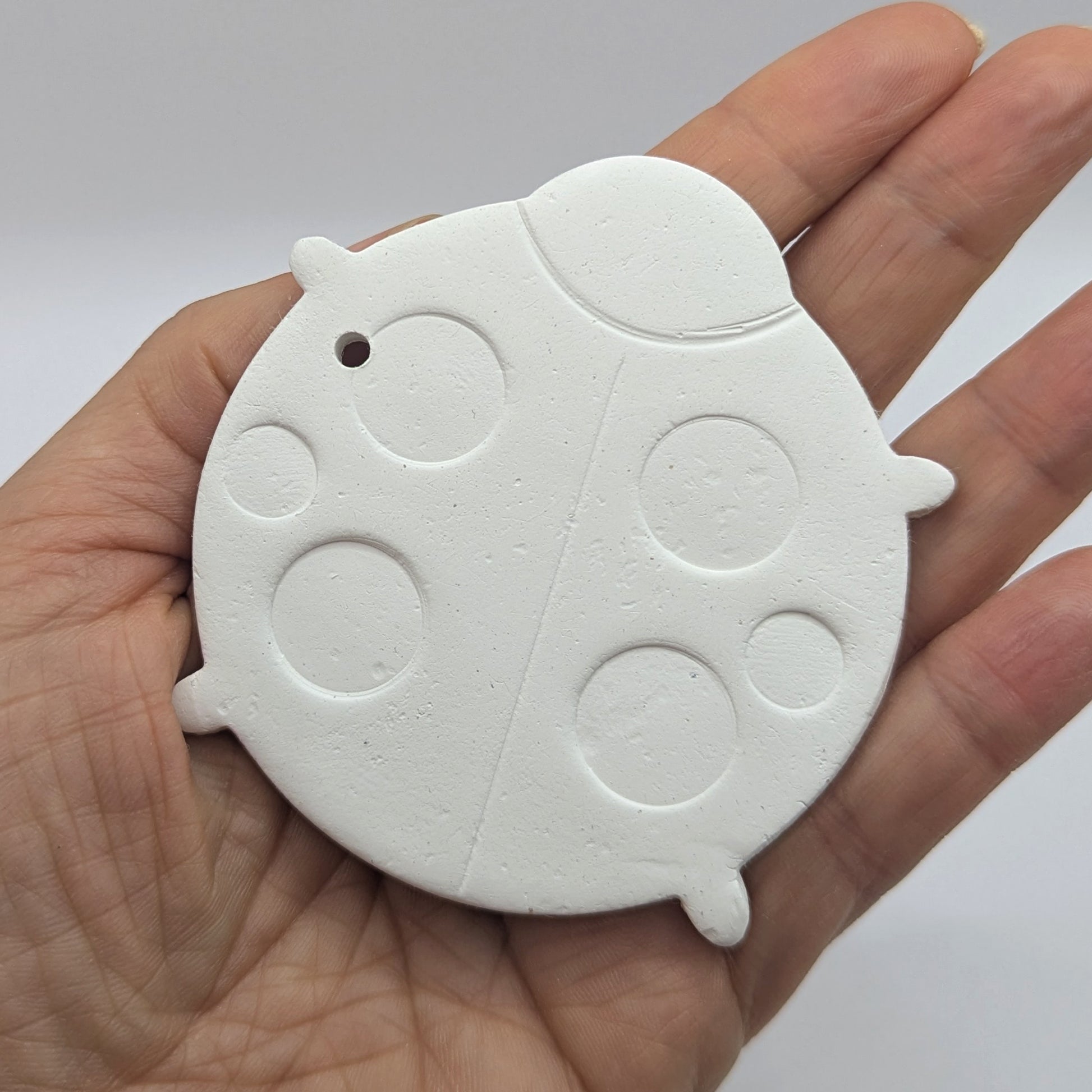 lady bird clay decoration shown in a ladies hand for scale, 6 large spots on back
