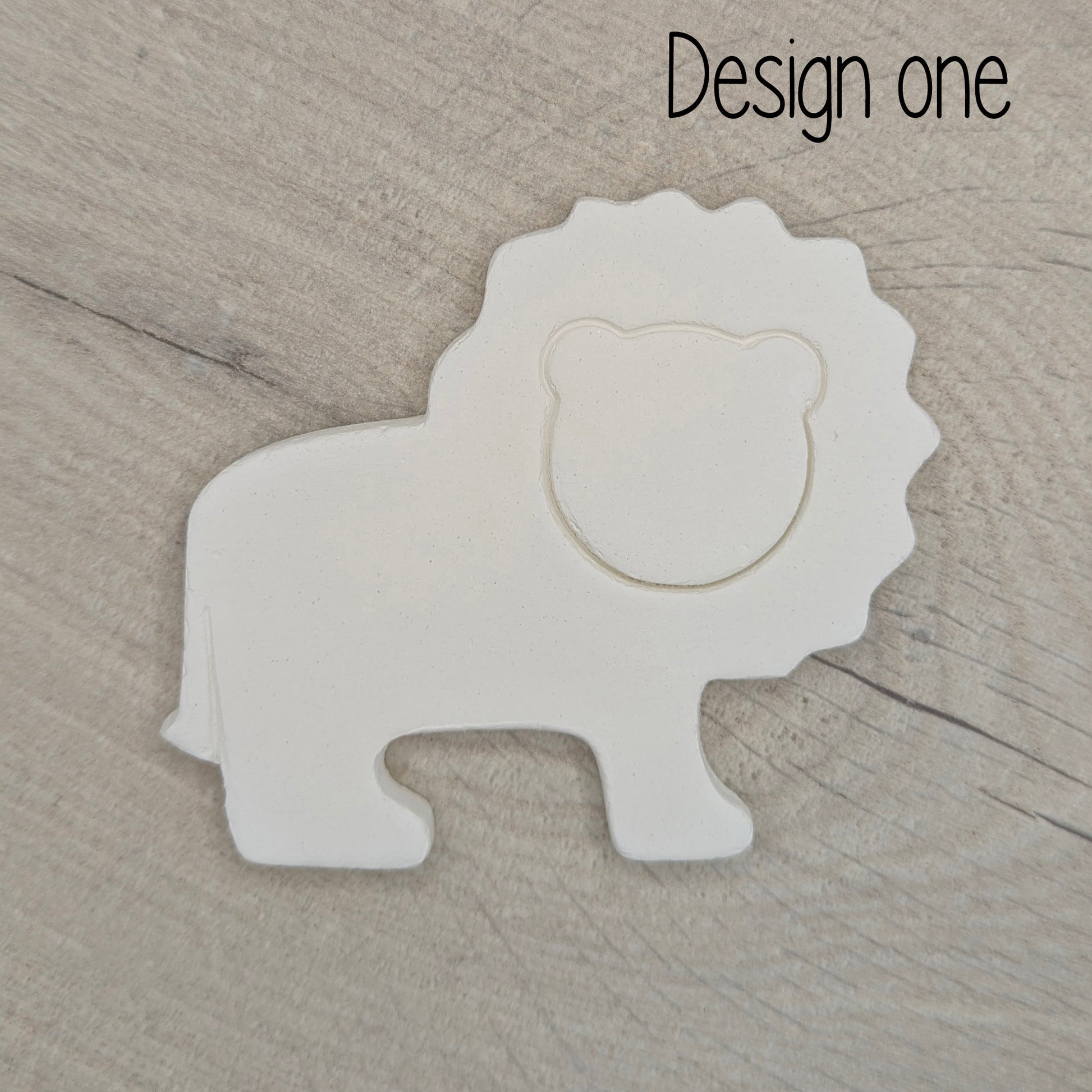 White lion-shaped decoration on a wooden surface with 'Design one' text.