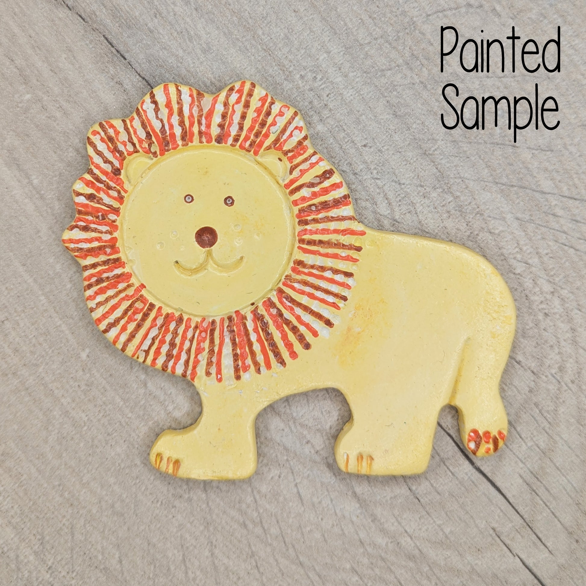 sample of a lion decoration, painted in pale yellow with a brown and orange mane