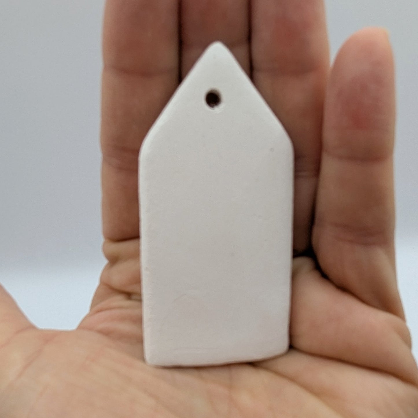 mini house decoration made of clay in palm of hand, can be used as a name tag too