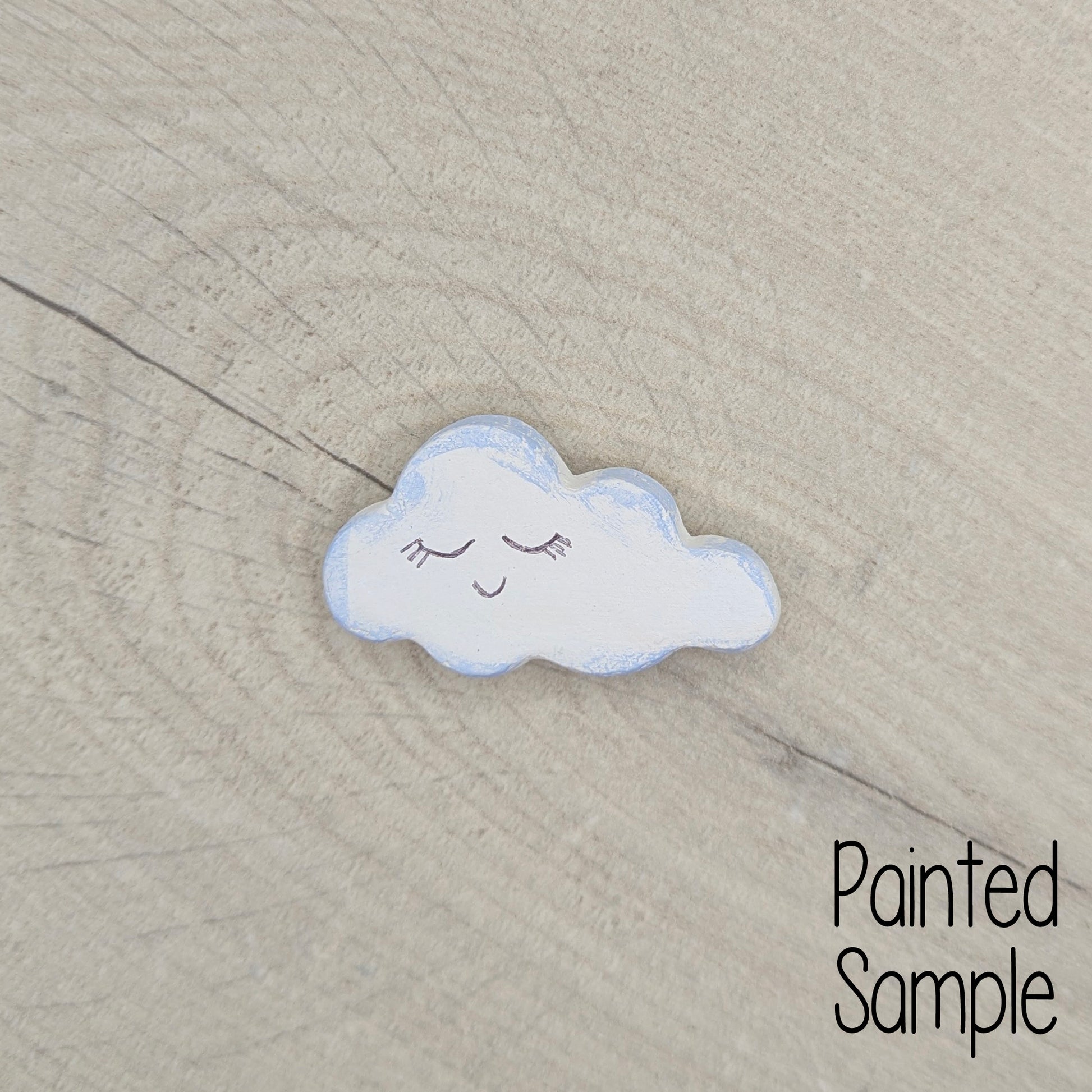 Decorative cloud with a smile on a textured wood surface, labelled 'Painted Sample'.