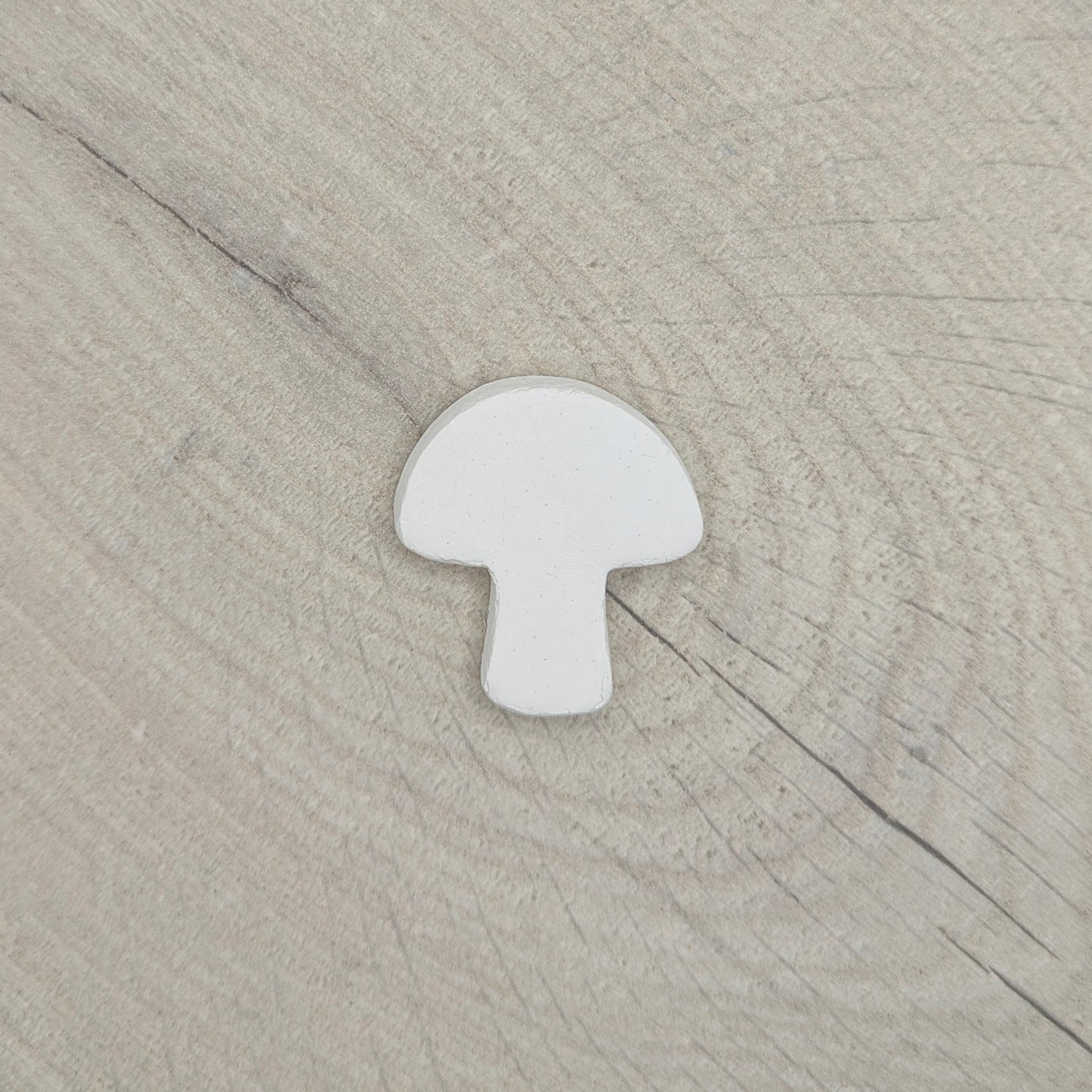 white clay mini shaped mushroom decoration on light wood background
