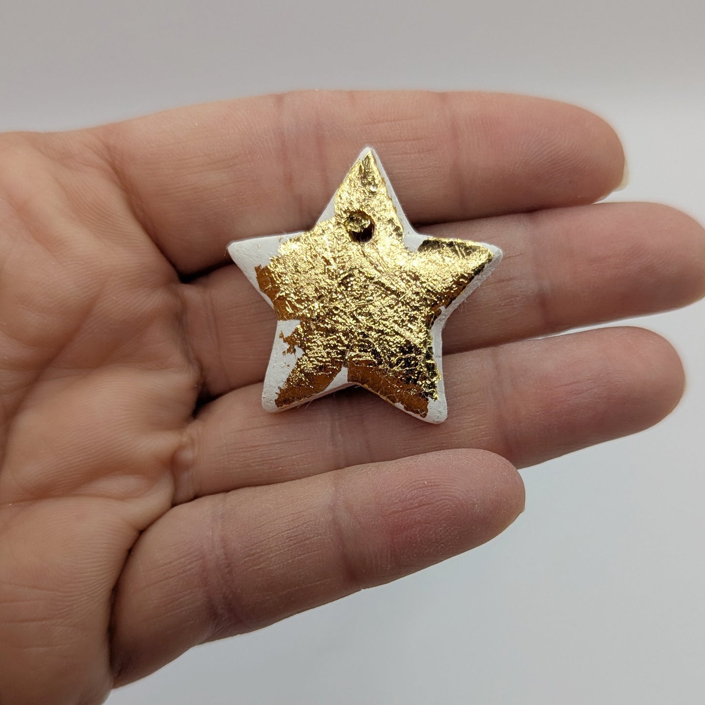 mini gold foil star shown in palm of hand