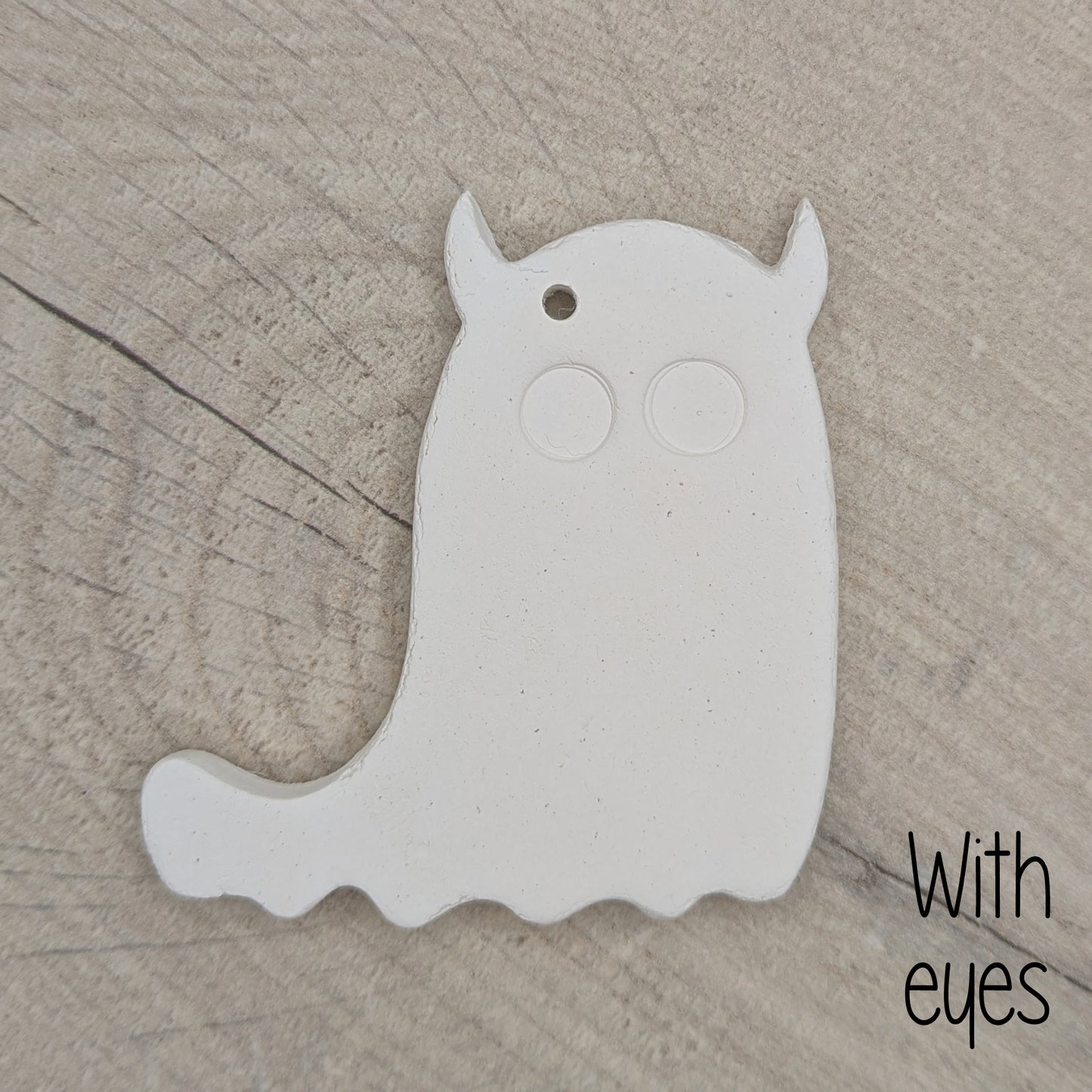 White ghost shaped clay deocration with 2 large eyes