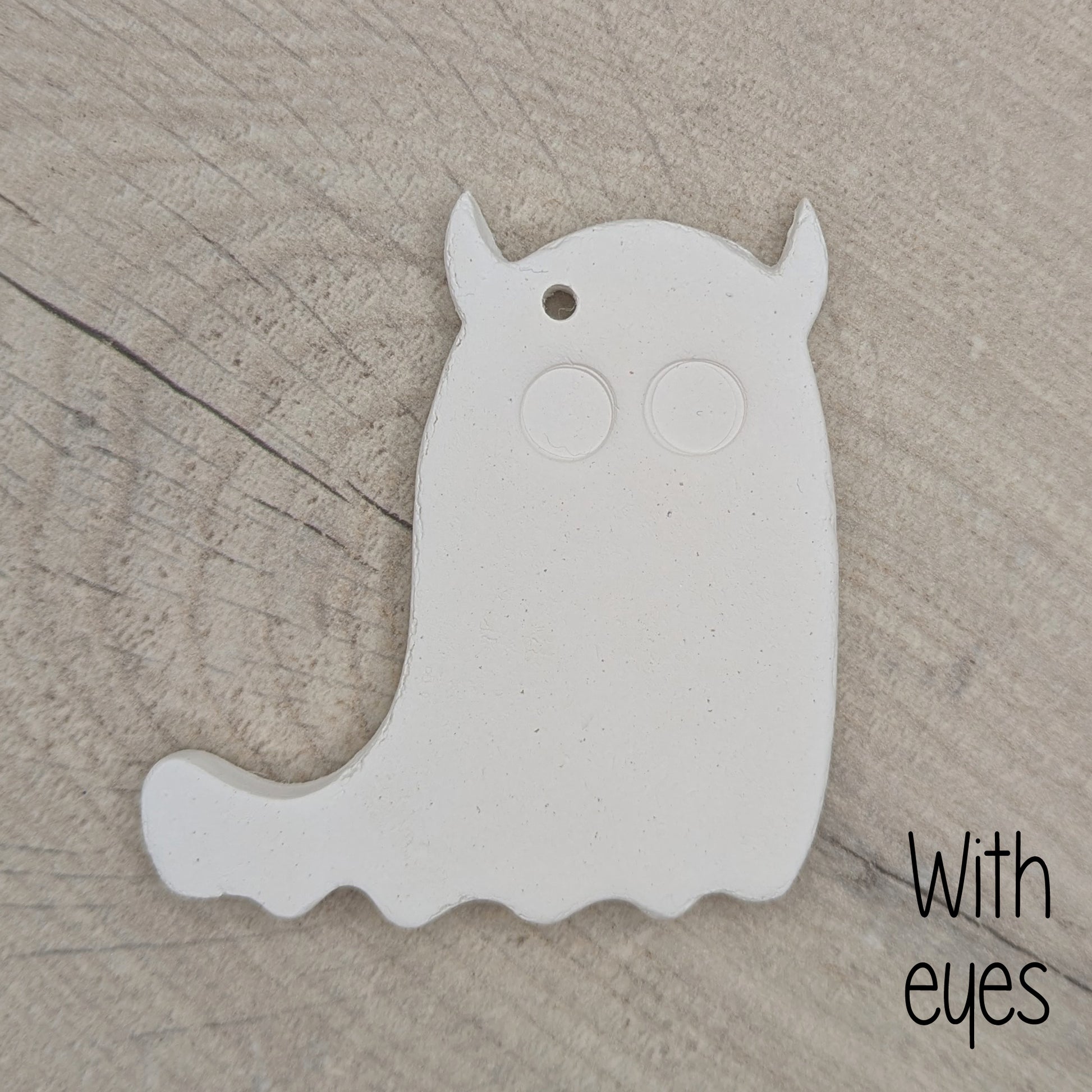 White ghost shaped clay deocration with 2 large eyes