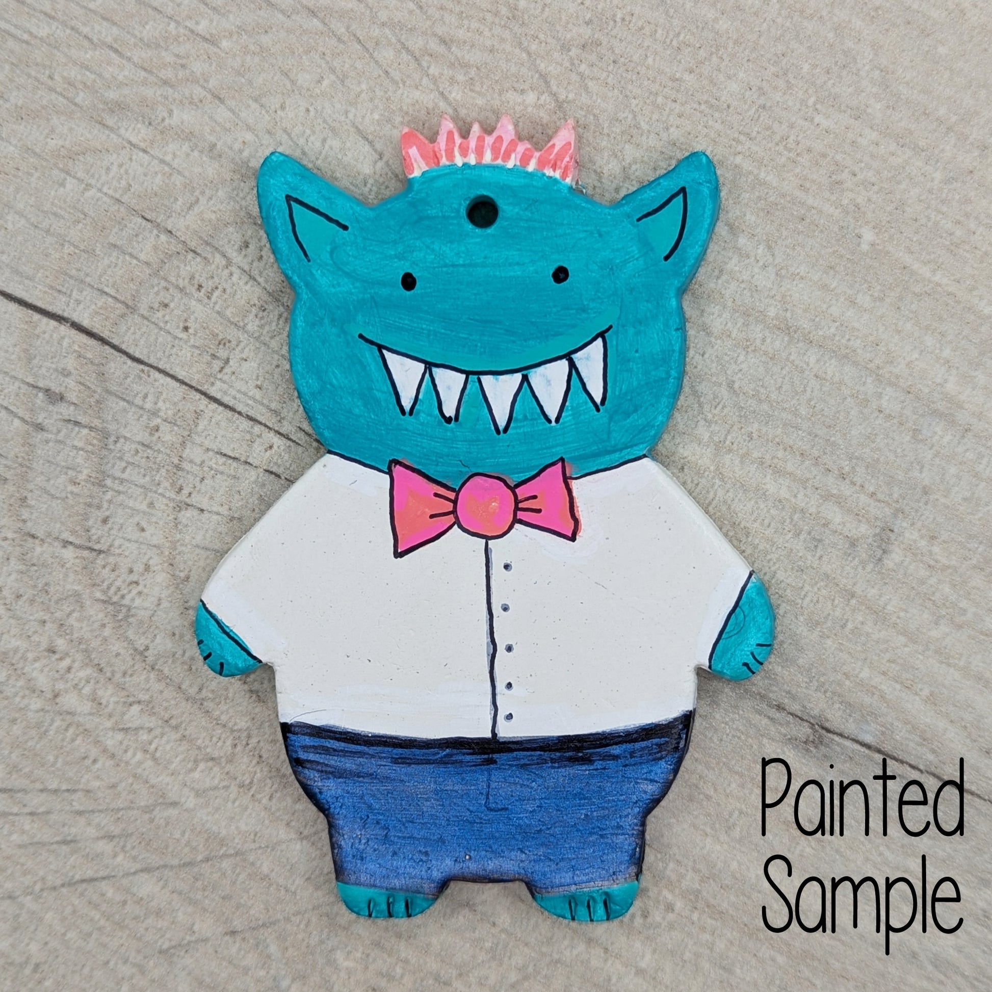 Painted sample of a spikey haired monster mainly in blue with a pink bow tie and pointy teeth, but cute