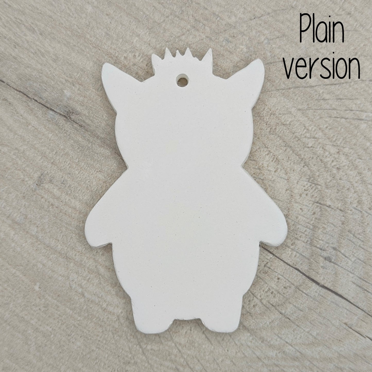 funky monster with spikey hair, a pointy pair of ears, on a wooden surface