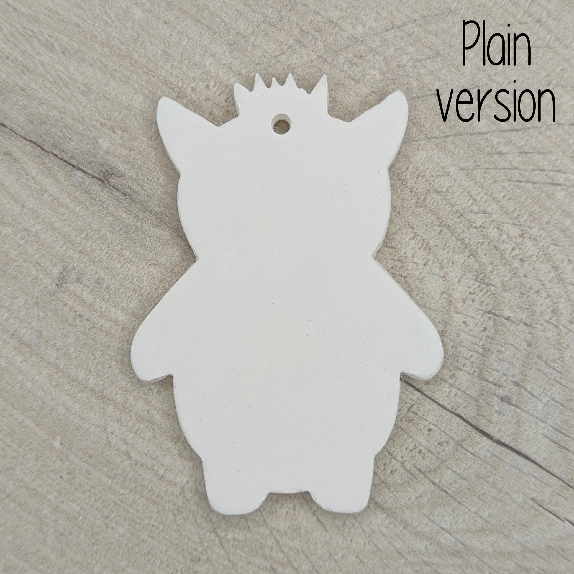 funky monster with spikey hair, a pointy pair of ears, on a wooden surface