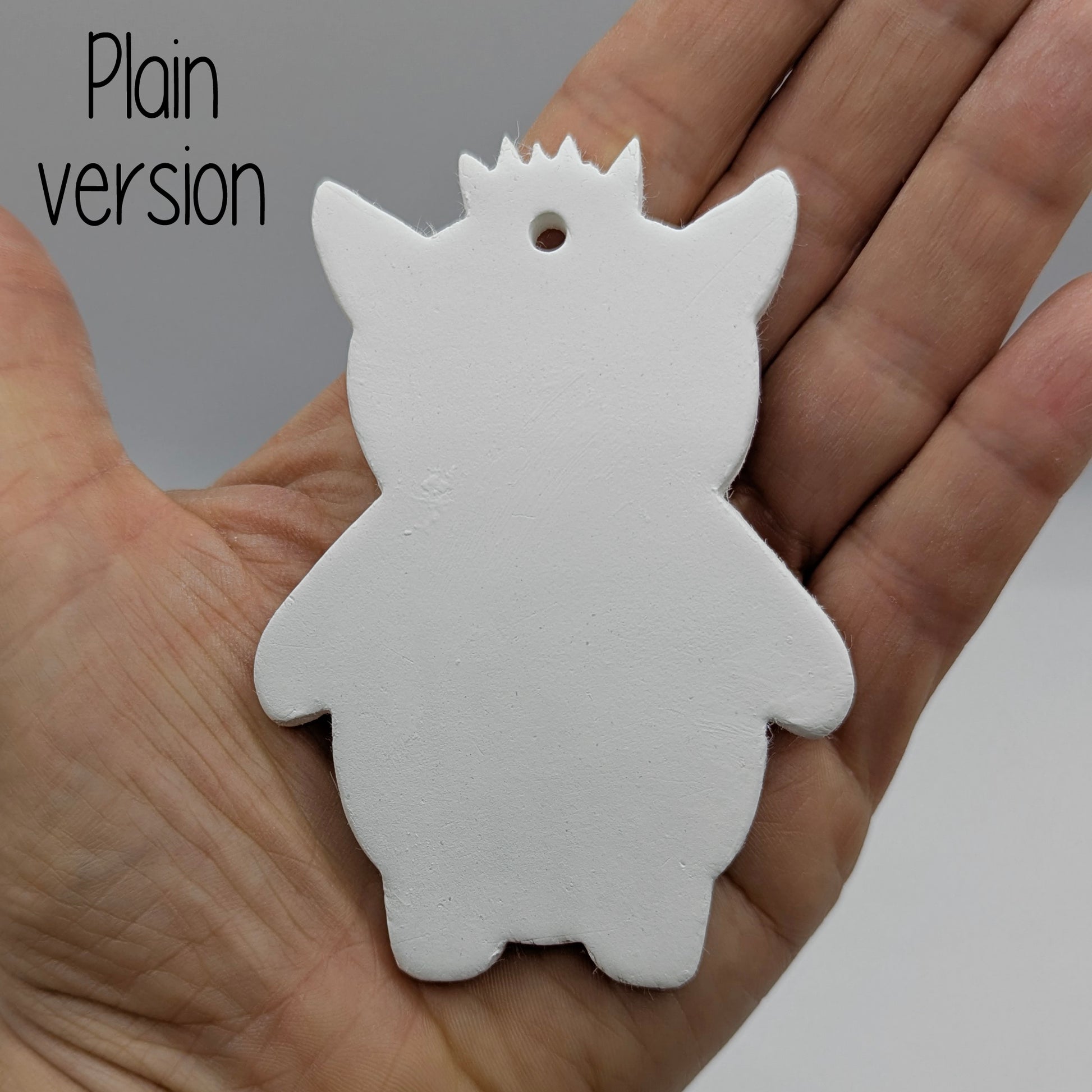 funky monster with spikey hair, a pointy pair of ears, held in hand for scale