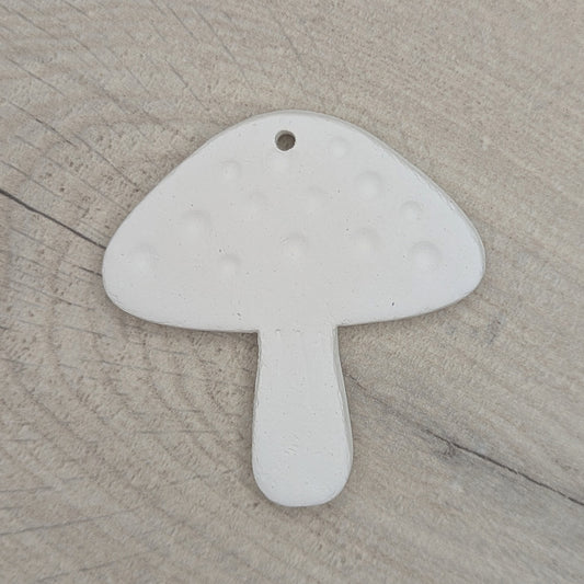 White clay mushroom-shaped decoration, on a wooden surface