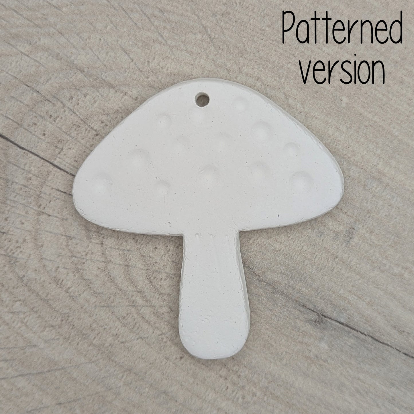 mushroom shaped clay decoration / tag on a wooden surface, patterned version