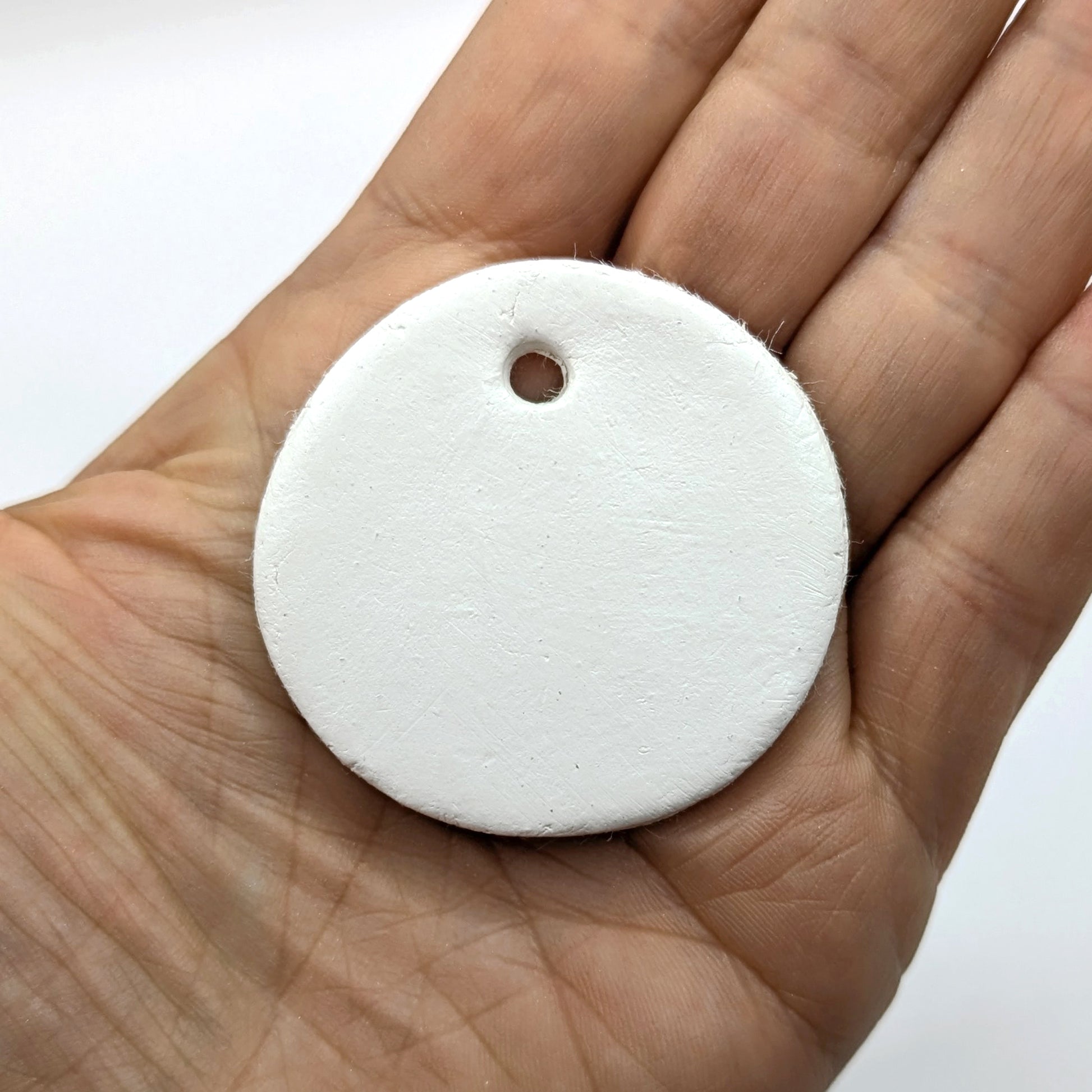 White clay tag held in a hand