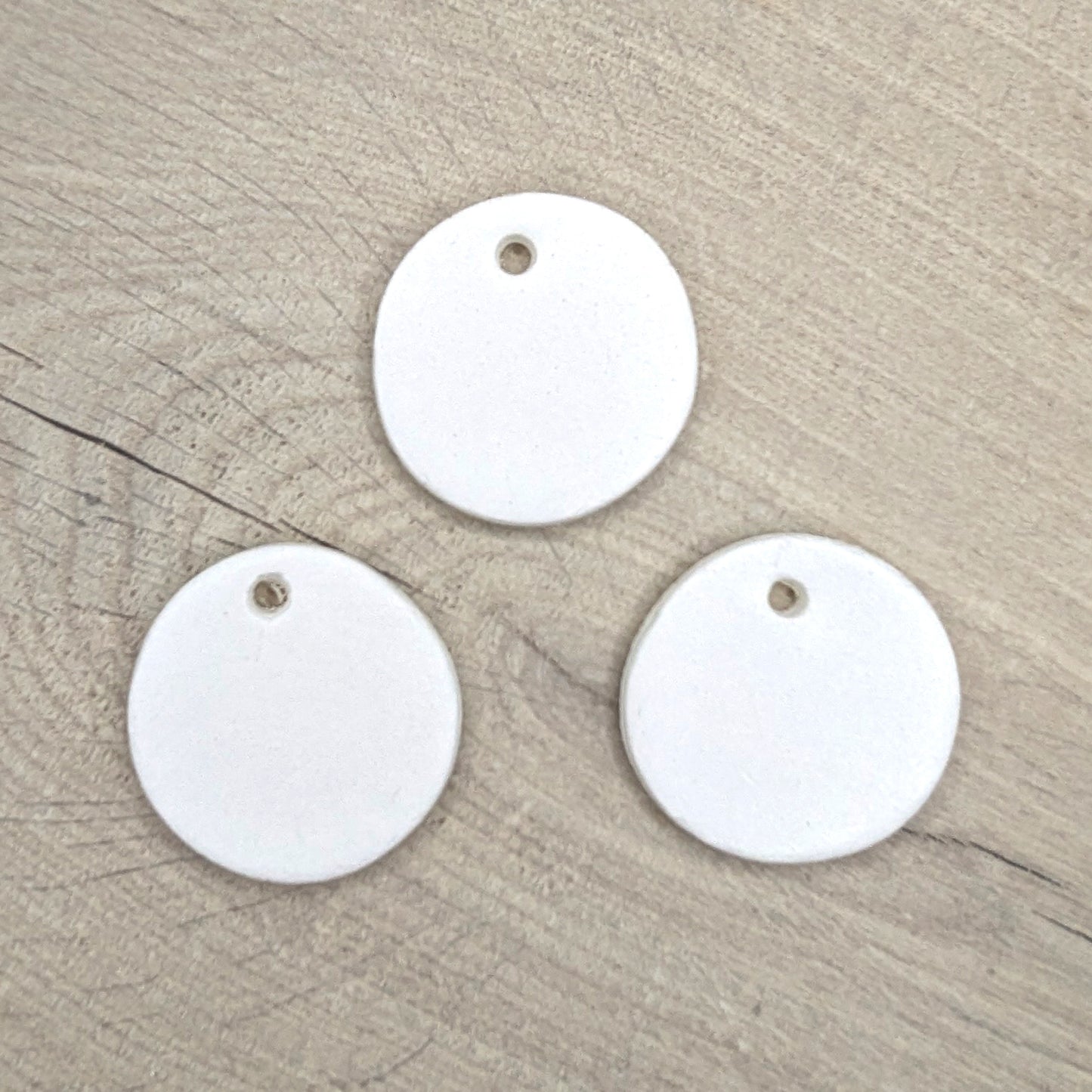 Three white round air dried clay tags with holes 