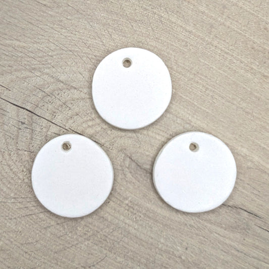 Three white round air dried clay tags with holes 