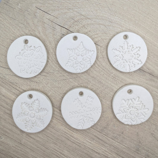 set of six white clay tags with snowflake patterns on - to show different designs