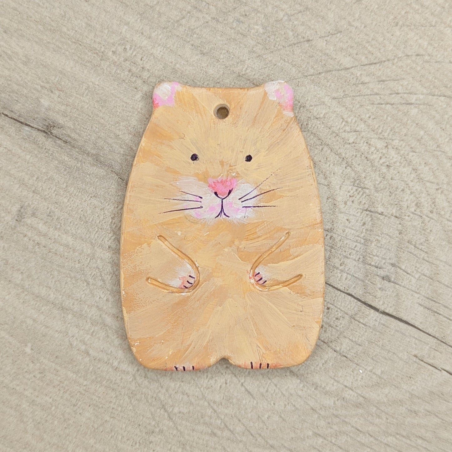 clay painted hamster decoration, on wooden background