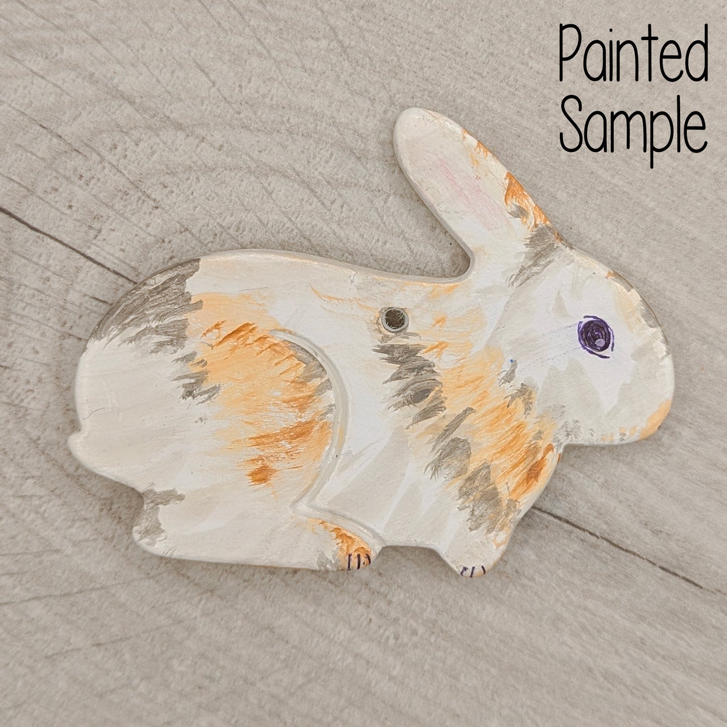 Painted sample of a rabbit decoration on a wooden surface