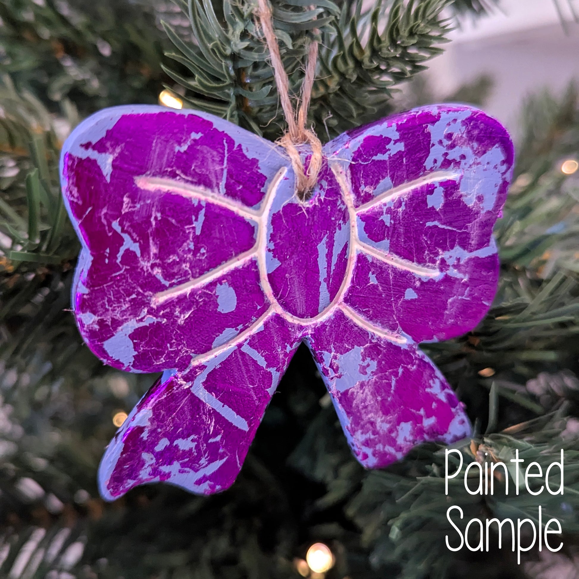 metalic purple bow shaped decoration displayed on a Christmas tree 