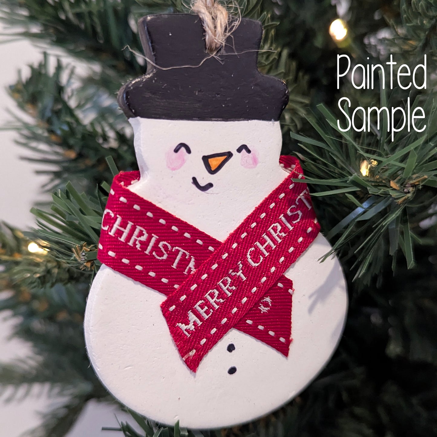 Painted snowman decoration with a red scarf on a Christmas tree
