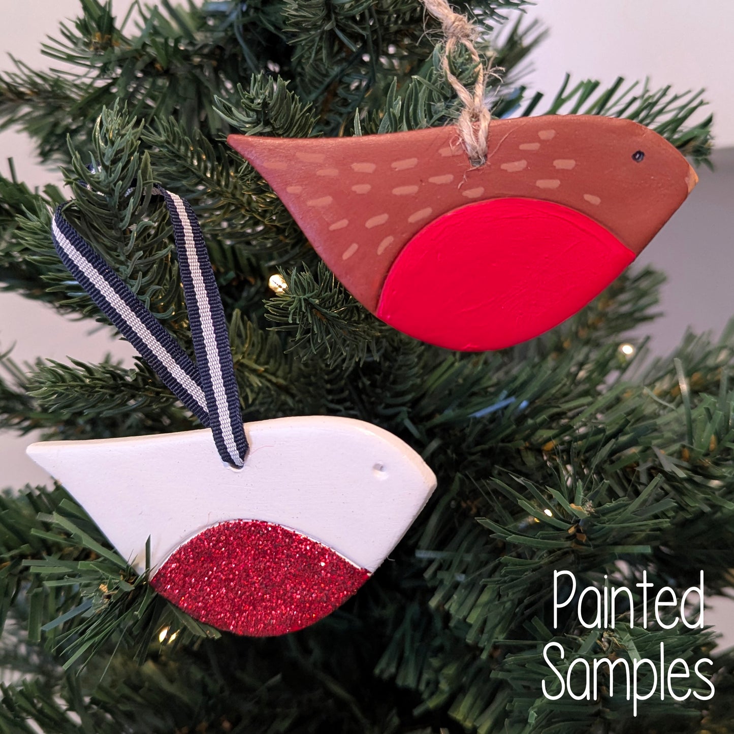 Two painted bird robin style ornaments on a Christmas tree 