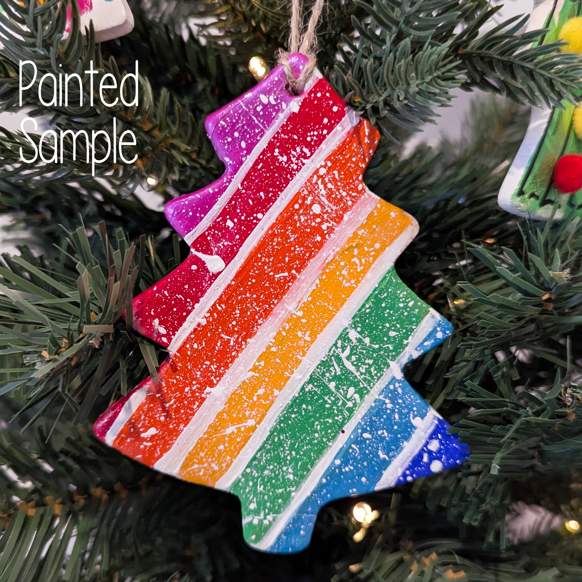 rainbow painted colourful christmas tree shaped decoration, displayed on a fake christmas tree