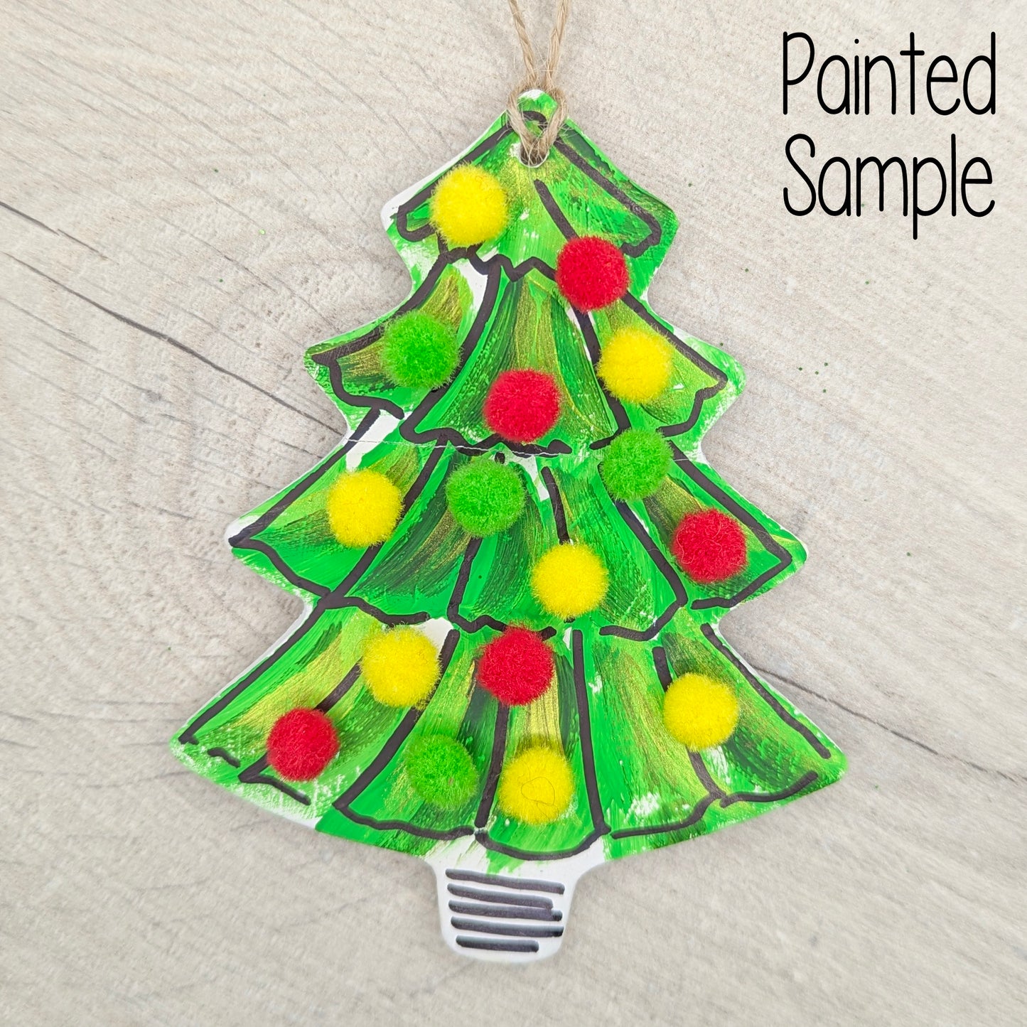 Decorative Christmas tree ornament with pom-pom decorations on a wooden surface