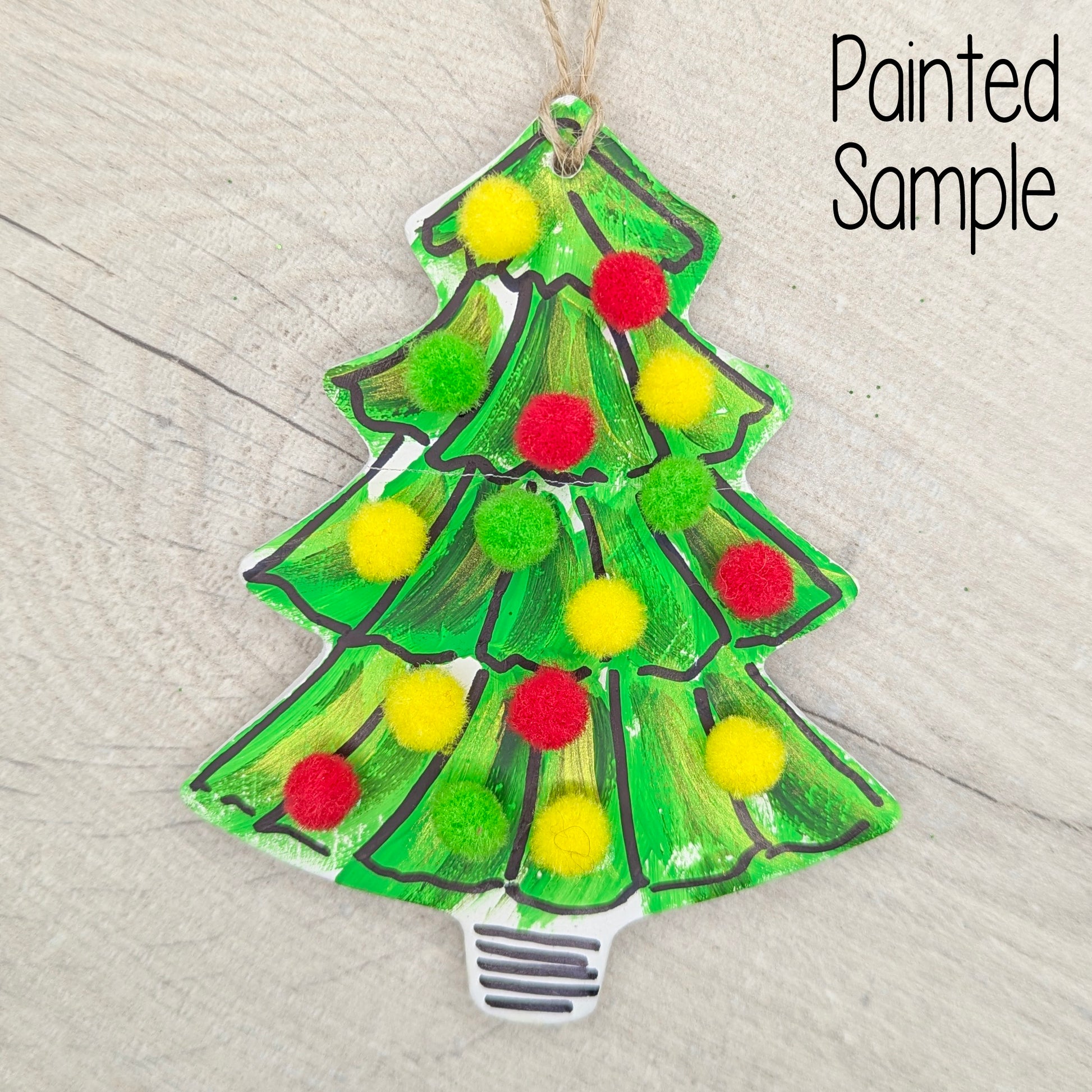 Decorative Christmas tree ornament with pom-pom decorations on a wooden surface