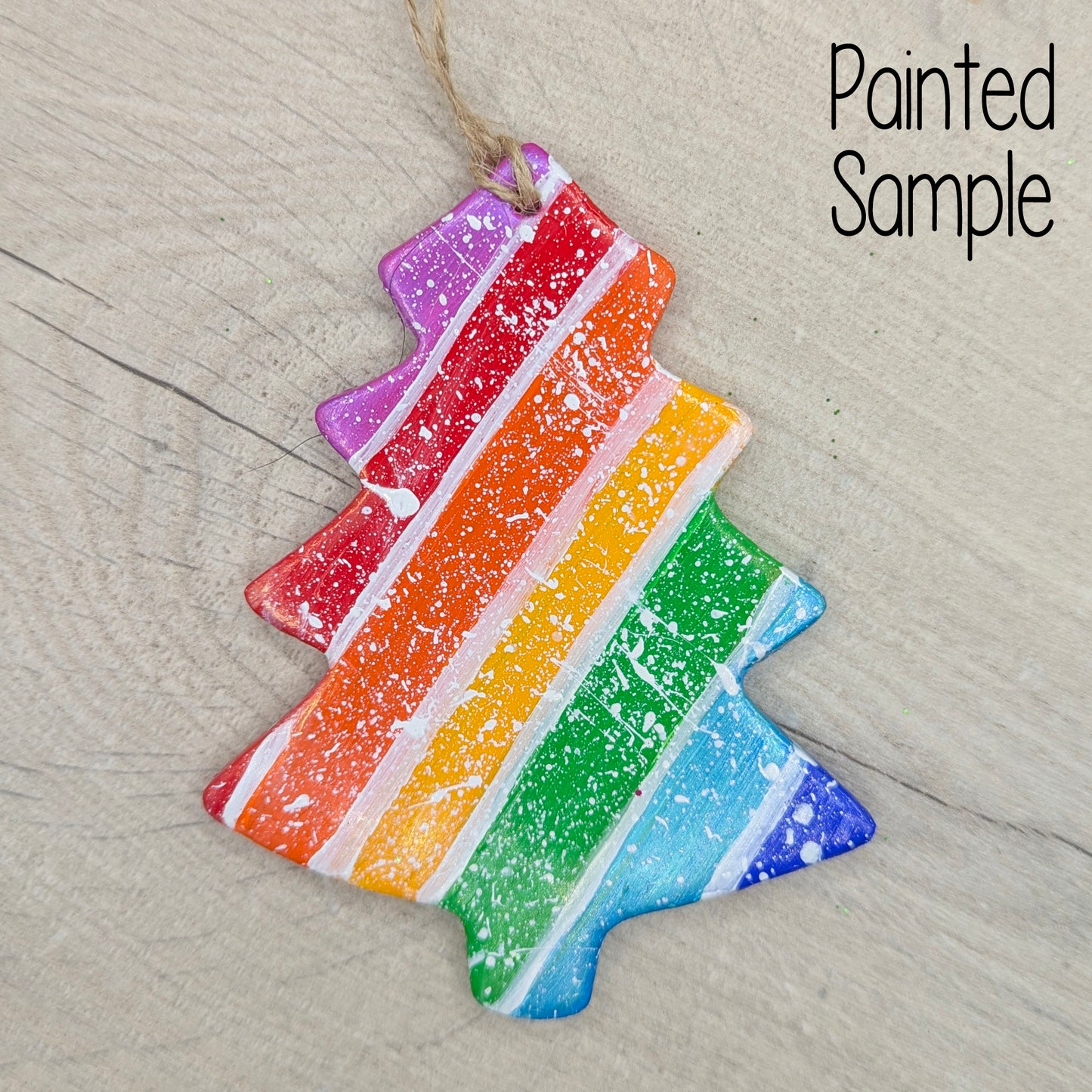 Colorful rainbow striped xmas tree shaped decoration on a textured wood surface 