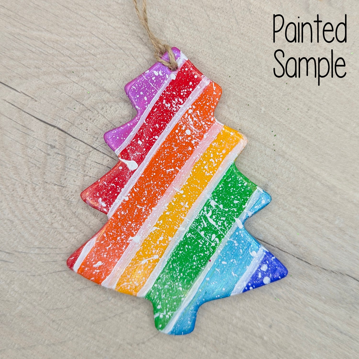 Colorful rainbow striped xmas tree shaped decoration on a textured wood surface 