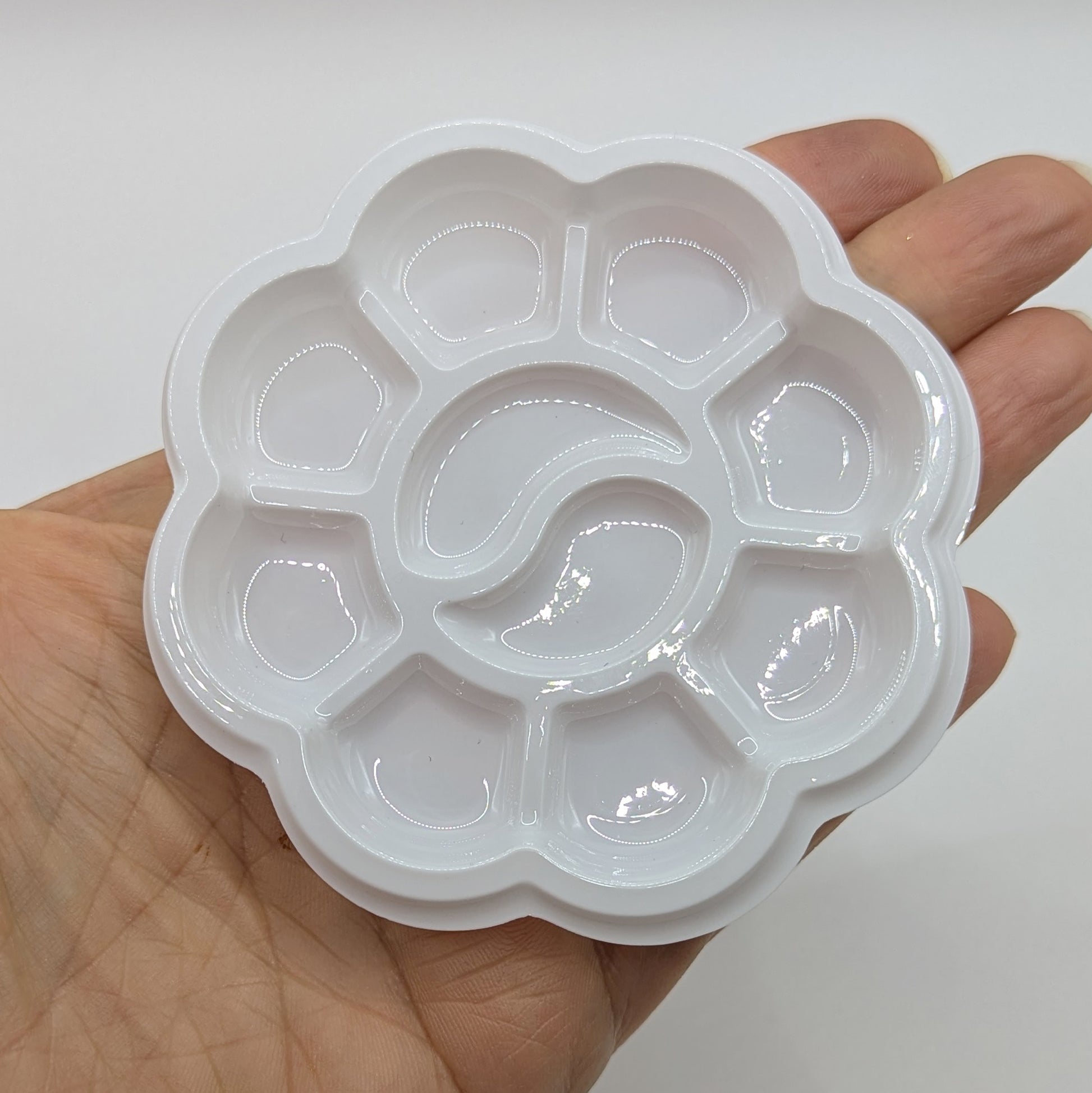small white paint mixing tray held in a hand