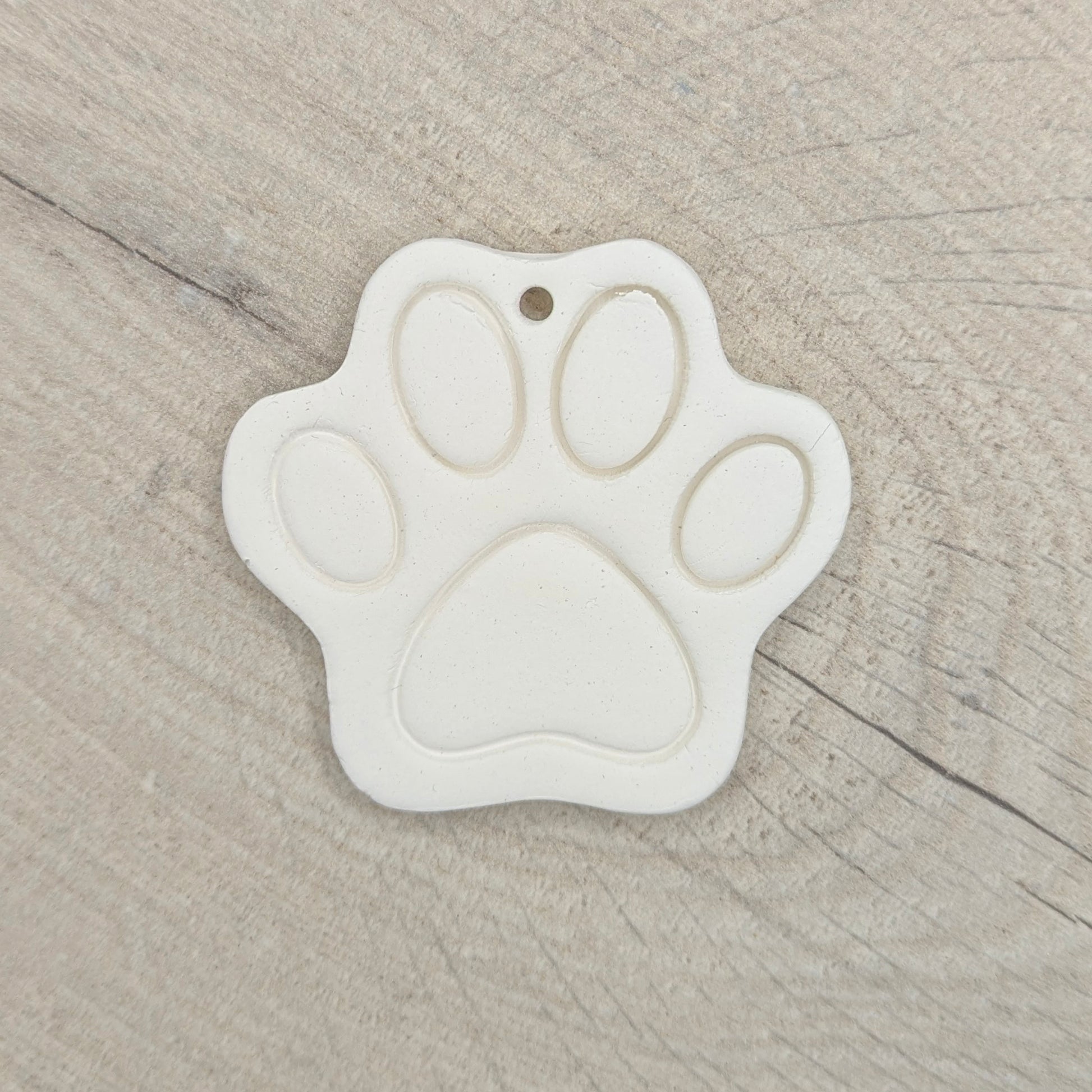 White paw print-shaped decoration on a wooden surface