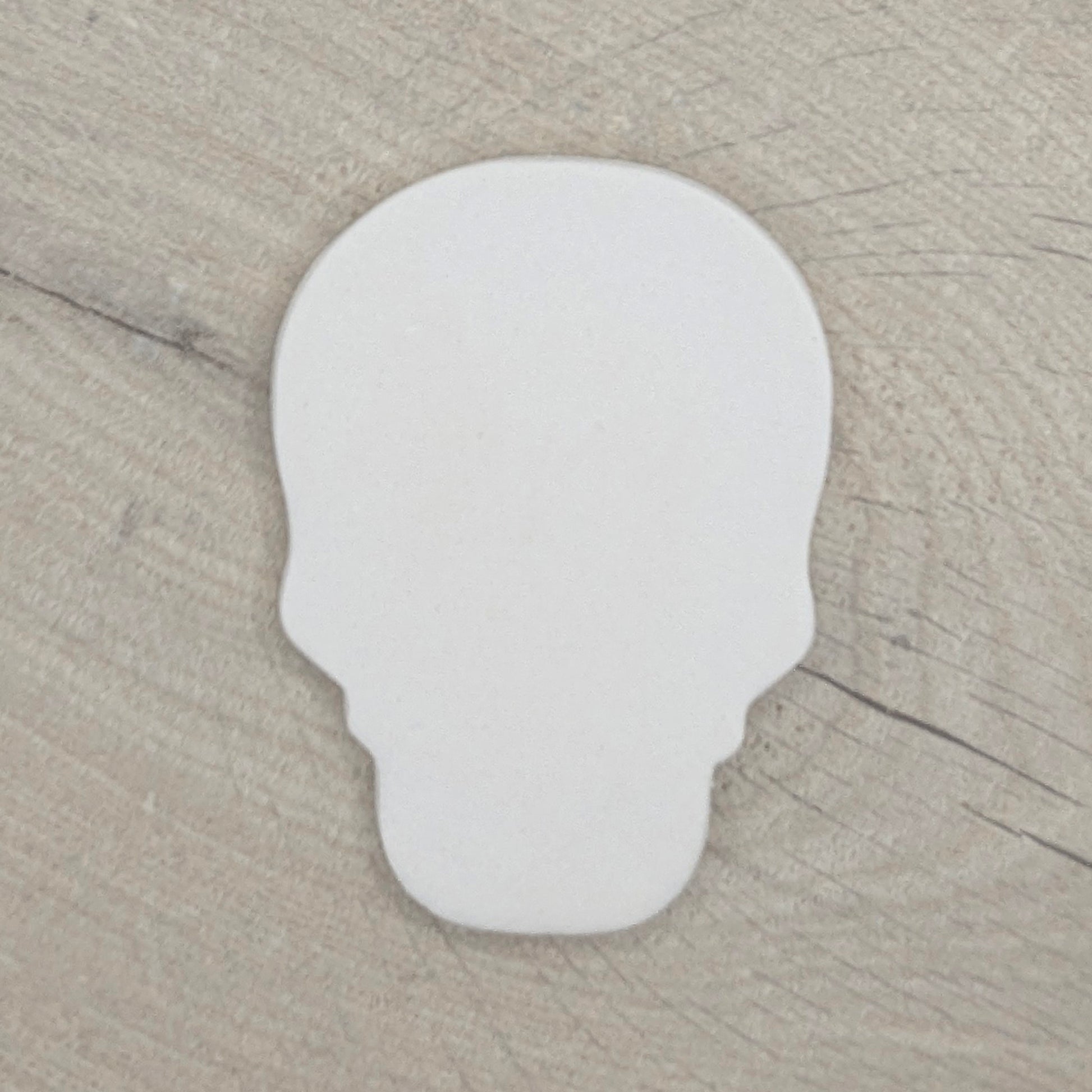 air dried clay decoration in the shape of a human skull on a wooden background