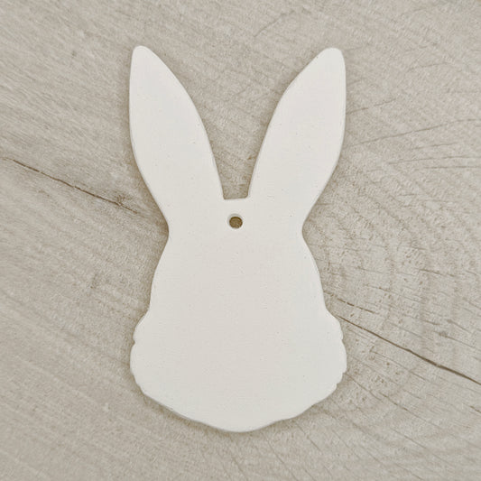 White clay bunny-shaped decoration on a wooden surface