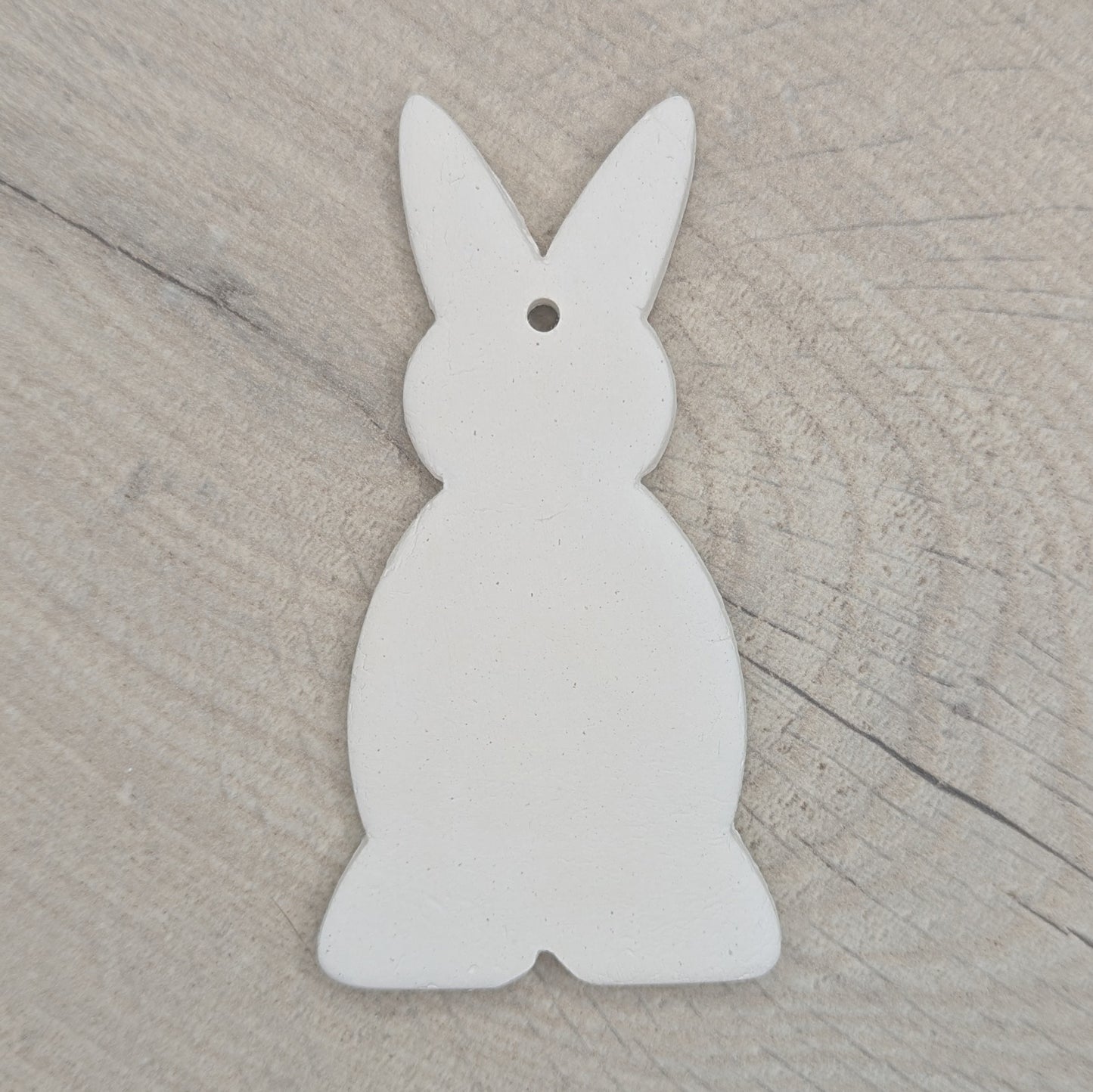 a clay decoration in the shape of a rabbit, made of air dried clay