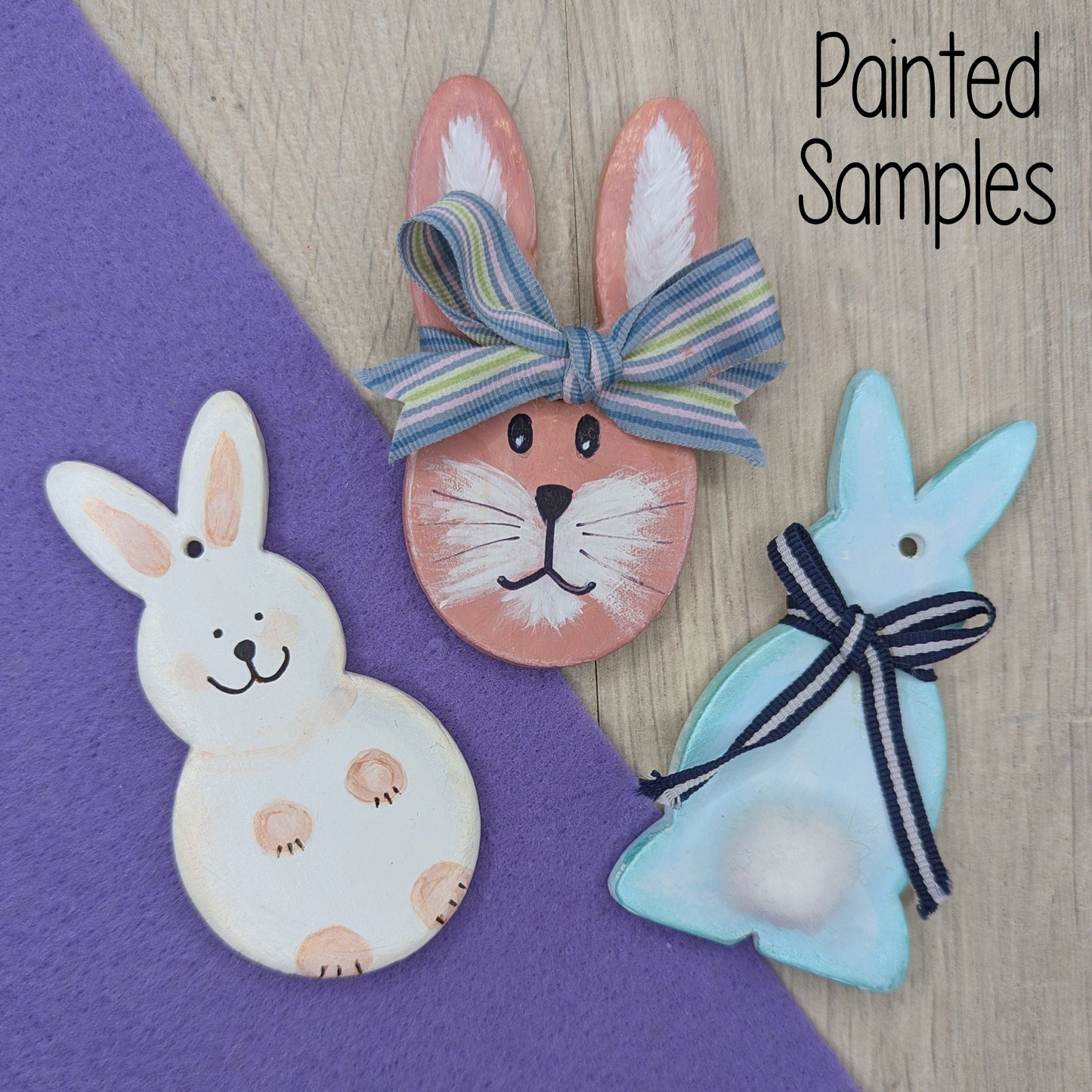 selection of clay rabbit decorations, one head and 2 full body ones, painted in pastel colours with ribbons to add extra details