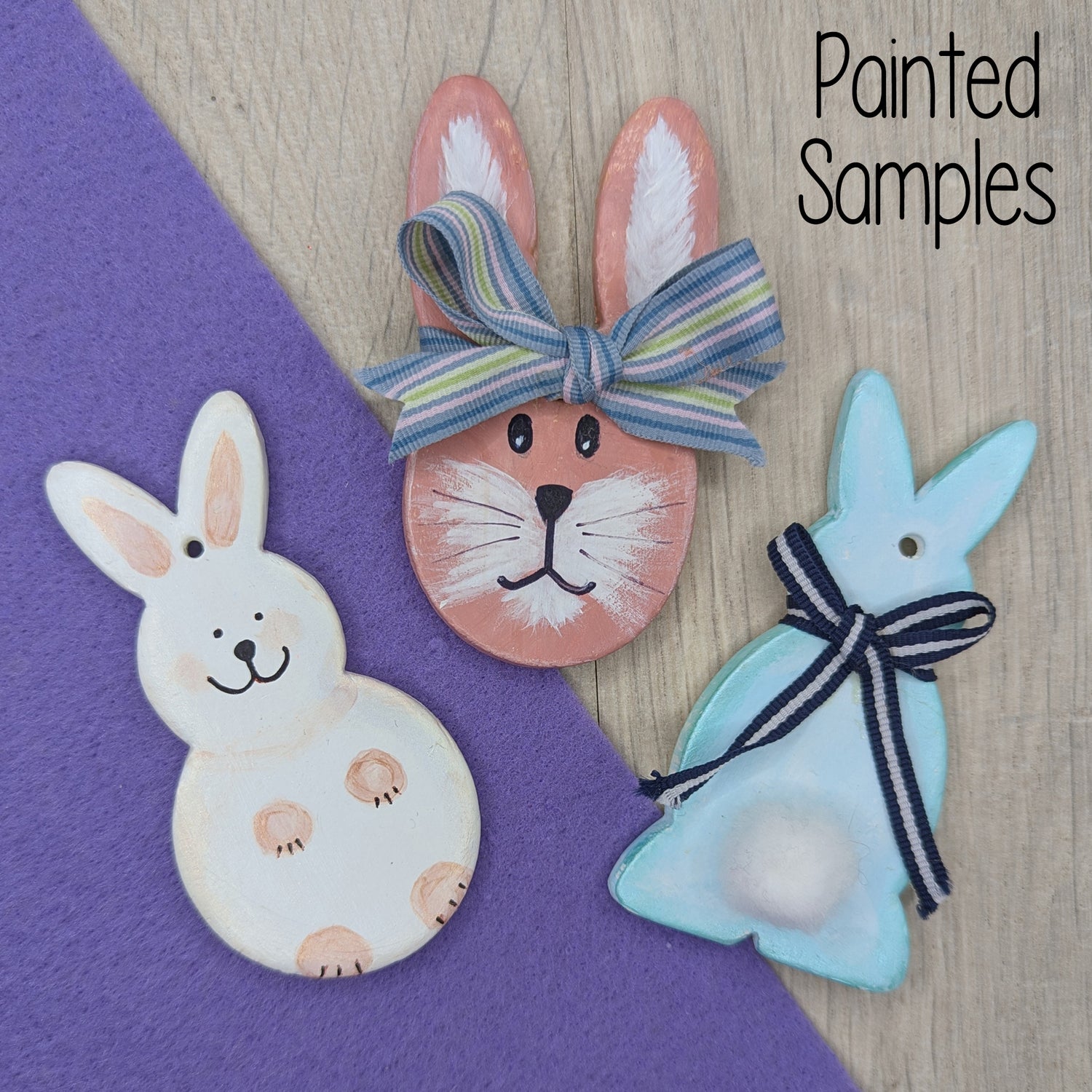 selection of clay rabbit decorations, one head and 2 full body ones, painted in pastel colours with ribbons to add extra details
