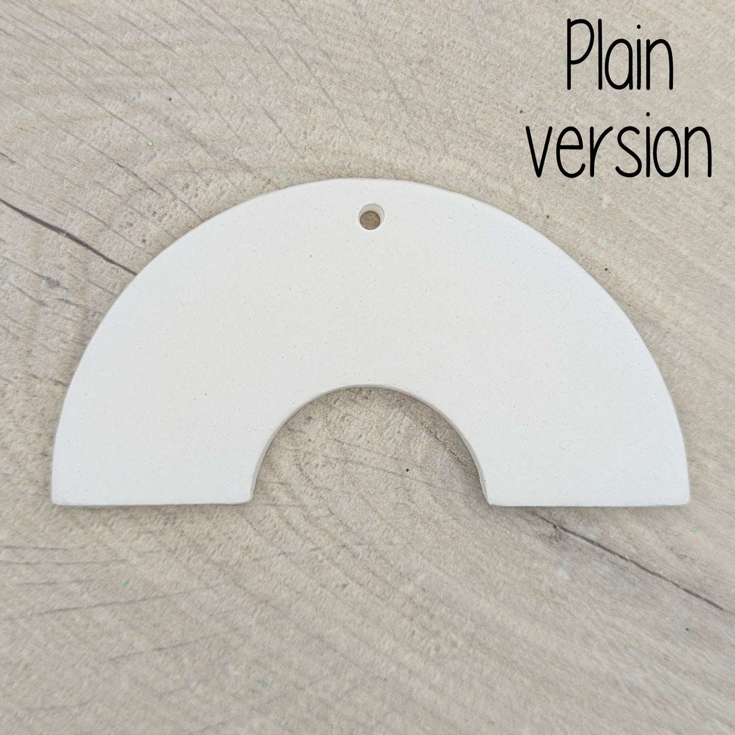 Plain white rainbow arch shaped decoration on a wooden surface 