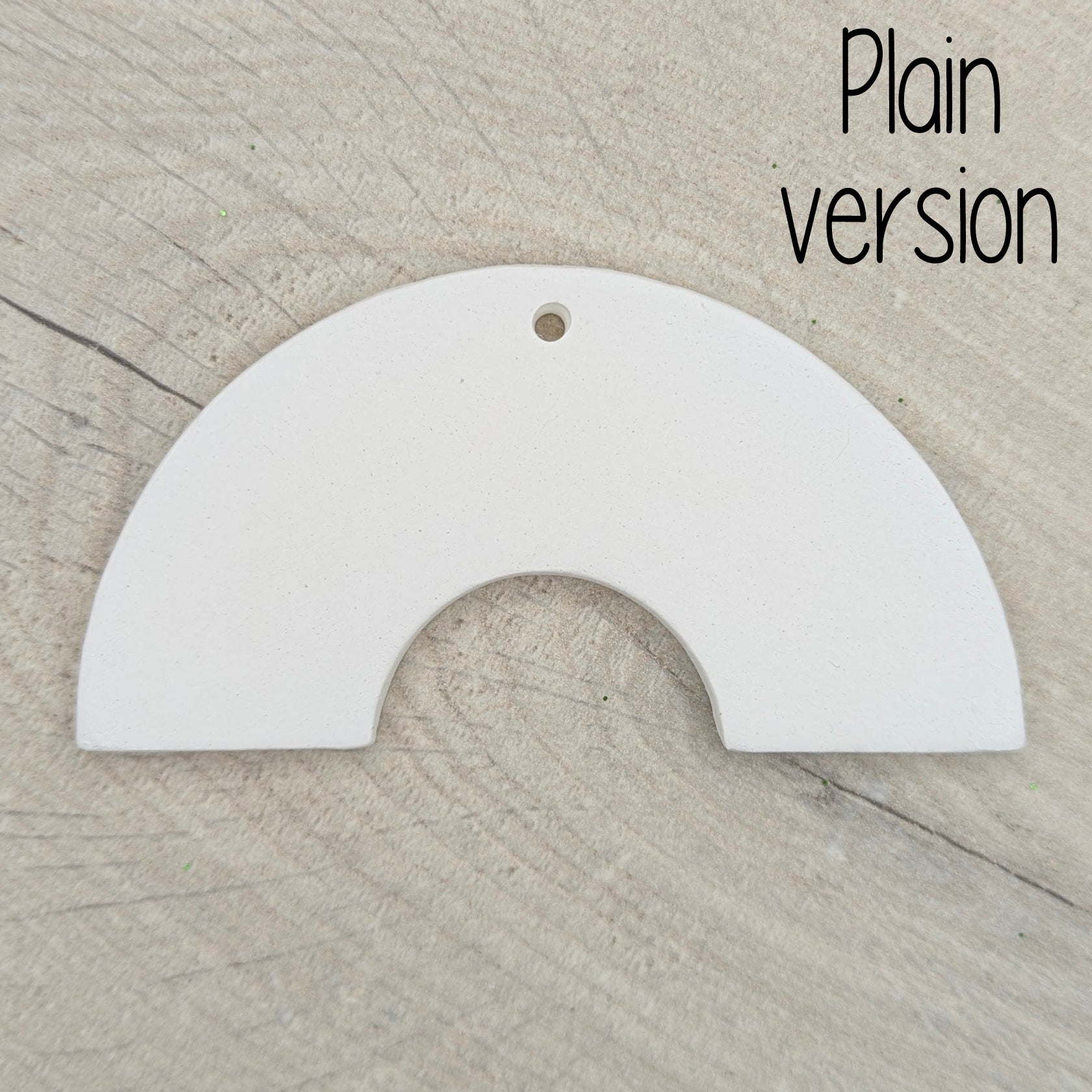 Plain white rainbow arch shaped decoration on a wooden surface 