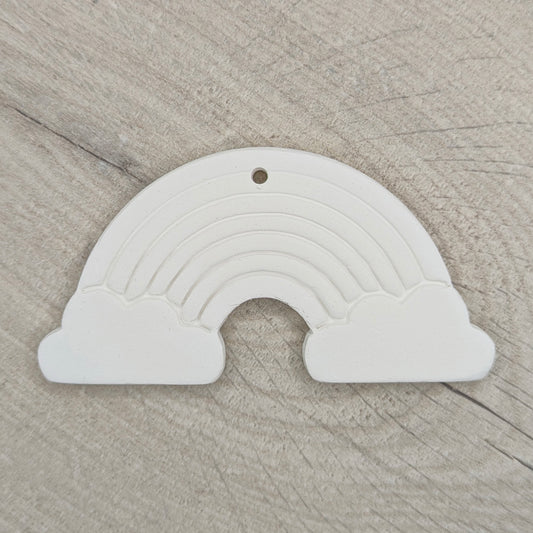 white air dried clay rainbow decoration shown on a light wood background