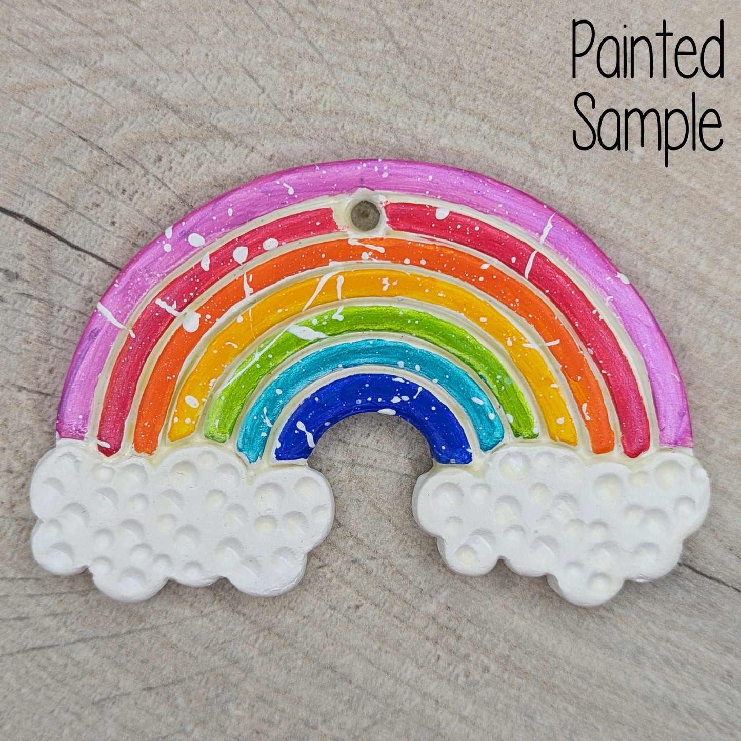 painted rainbow clay decoration, painted in bright and bold colours with white clouds