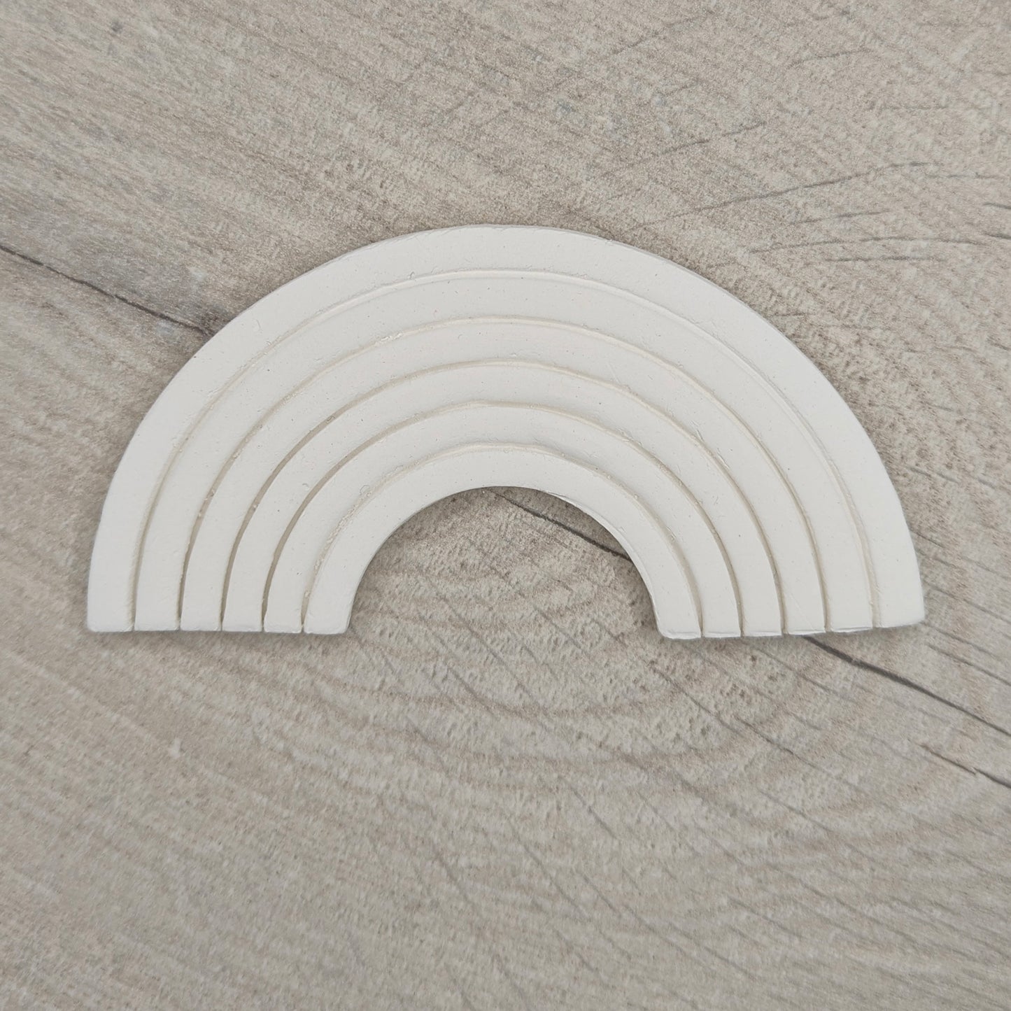 white clay rainbow on a light wood background