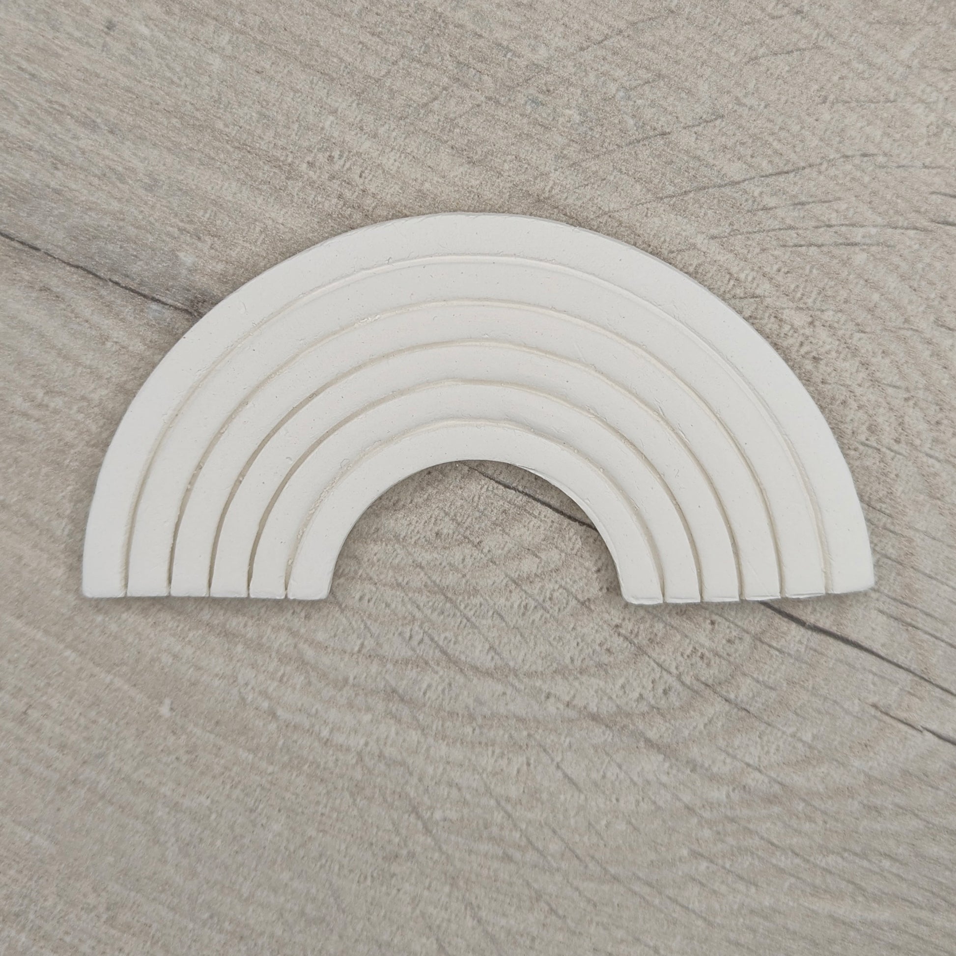 white clay rainbow on a light wood background