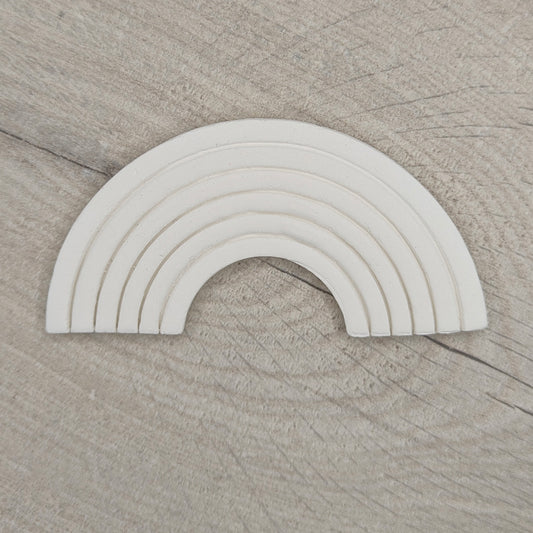 white clay rainbow on a light wood background