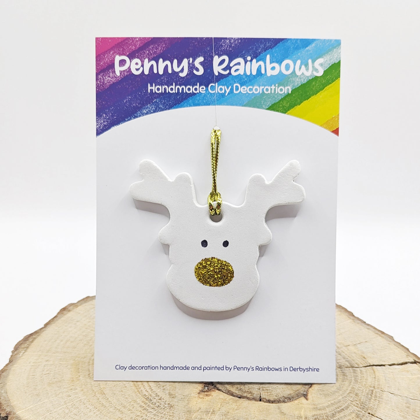 White clay reindeer decoration with gold glitter nose on a Penny's Rainbows branded card