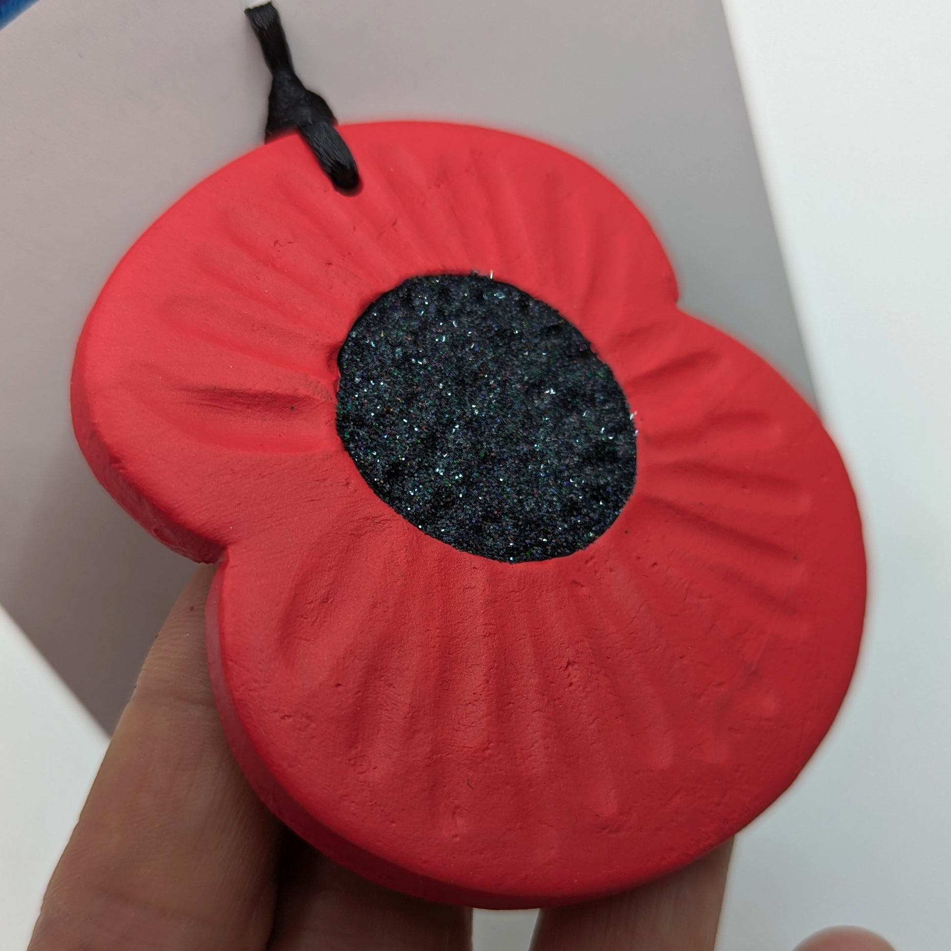 handmade poppy clay decoration, petals painted in red and centre is black glitter