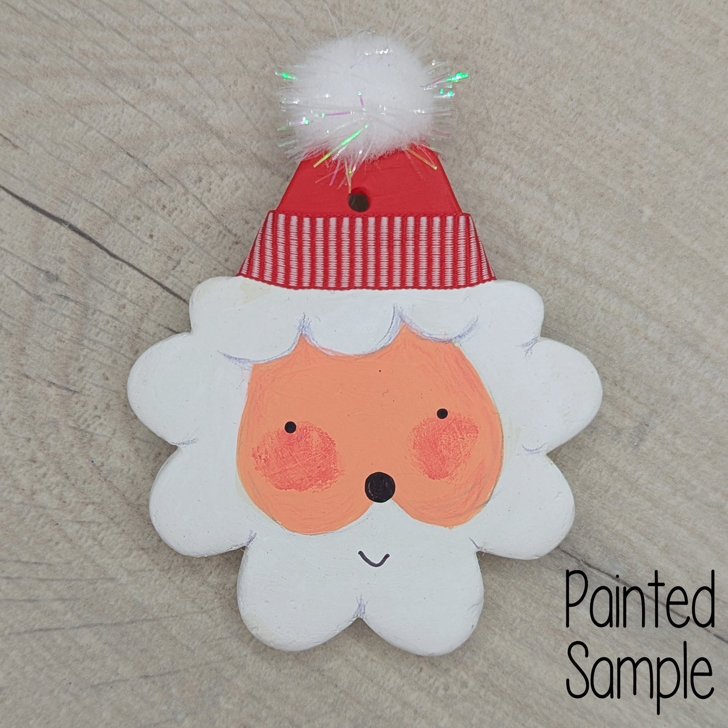 Painted sample of my santa clay decoration, happy face with a red hat with a sparkly pom pom on top