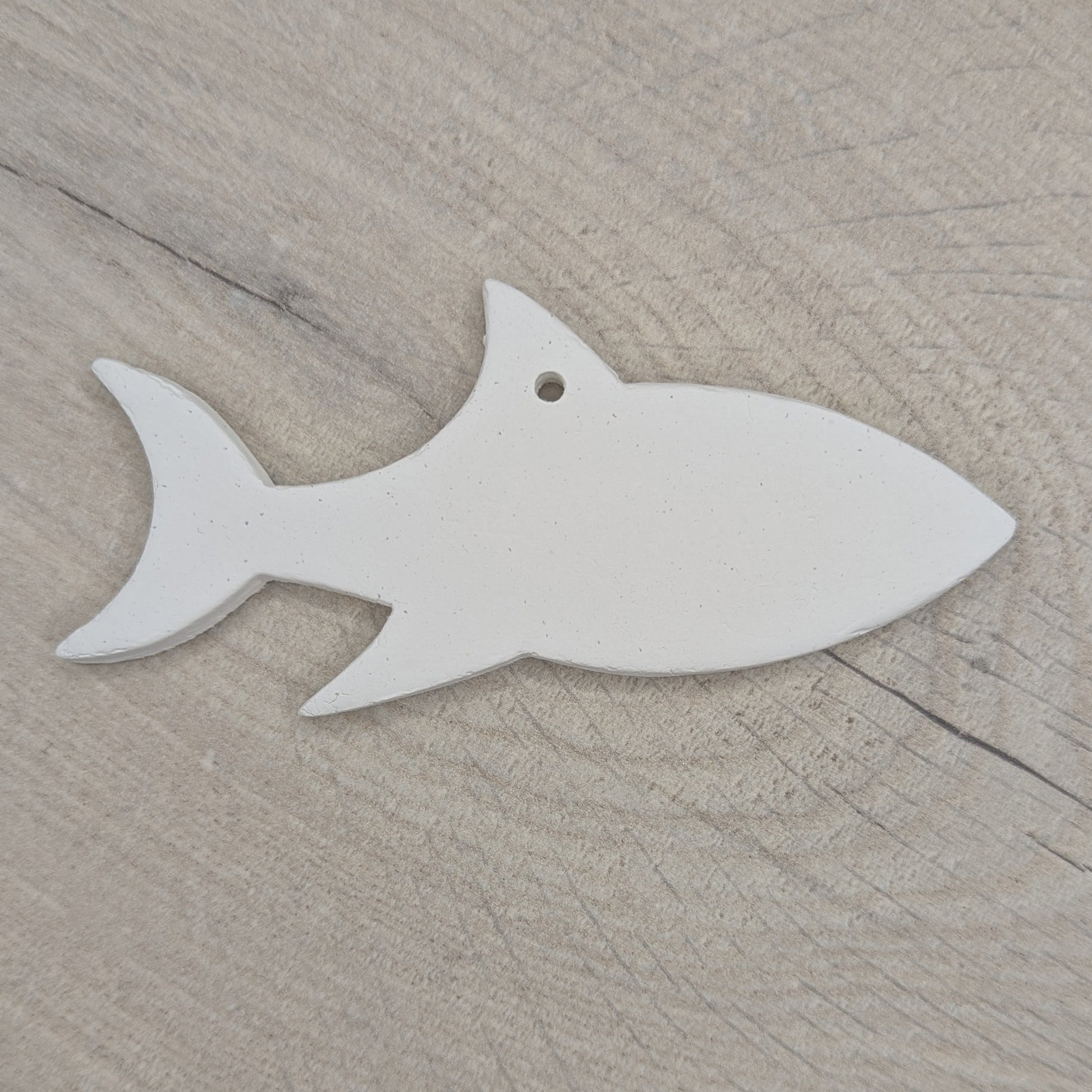 white air dried clay decoration in the shape of a shark