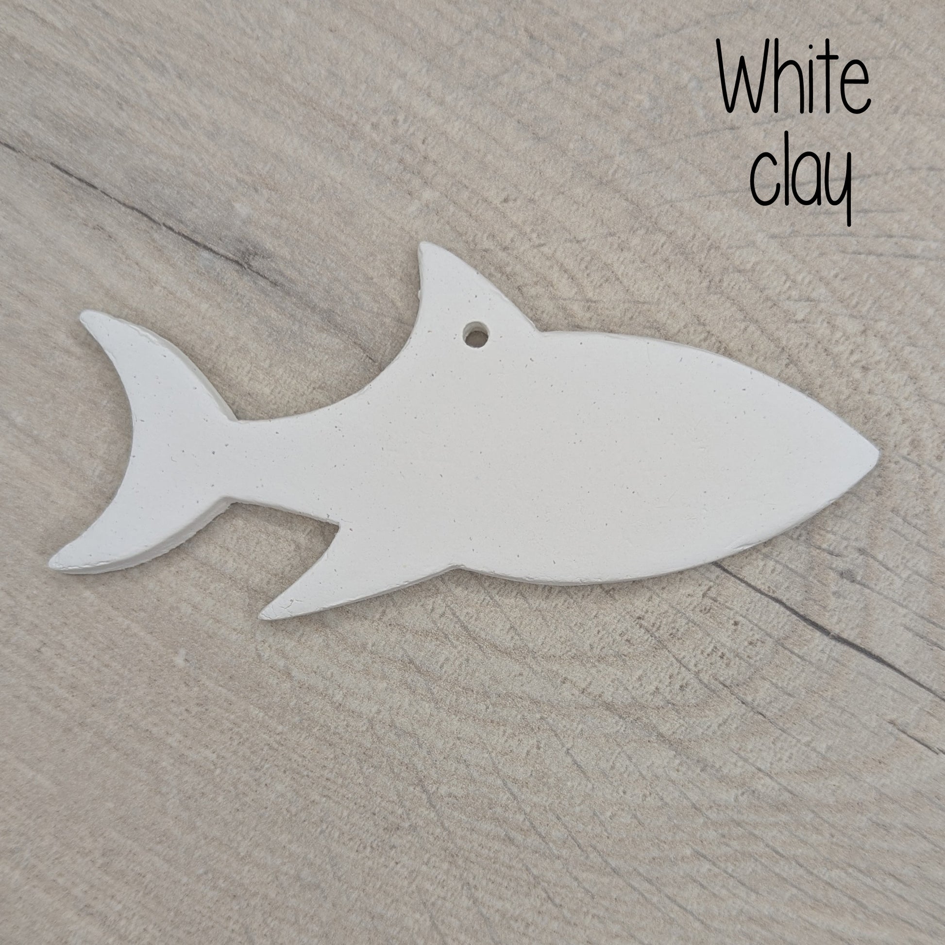 white air dried clay decoration in the shape of a shark