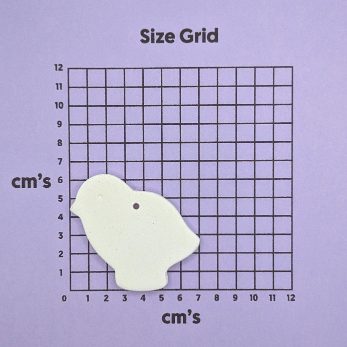 small clay chick decoration on a size grid chart